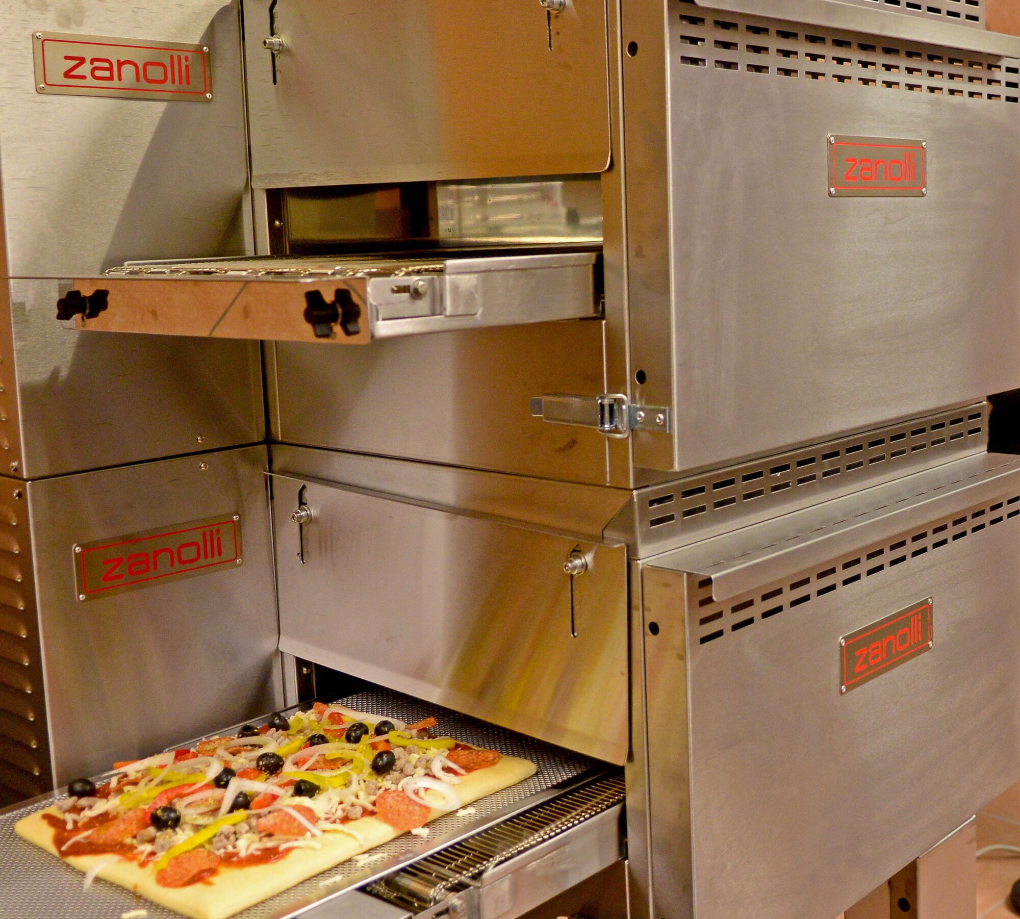 The La Bella Vista club recently installed a new conveyor belt style oven that can cook up to five pizzas in about 17 minutes. In the future the La Bella Vista staff is hoping to begin a delivery service, to help accommodate Airmen on base. (U.S. Air Force photo/Senior Airman Briana Jones)