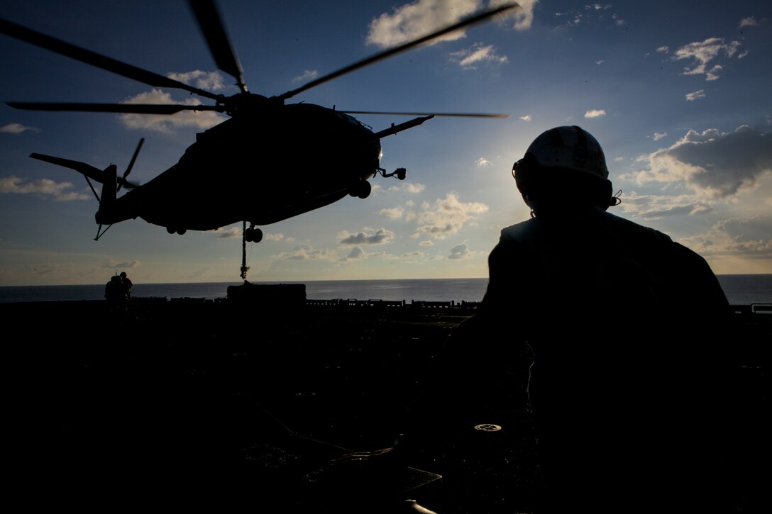 A landing support specialist with Combat Logistics Battalion 31, 31st Marine Expeditionary Unit, watches a CH-53E Super Stallion helicopter with Marine Medium Tiltrotor Squadron 265 (Reinforced), 31st MEU, prepare to lift a load of cargo off the flight deck here, Sept. 13. The Helicopter Support Team of CLB-31 and the crews of the helicopters play important roles in the 31st MEU’s capability to execute external lifts. The HST provides ground support to the CH-53E, which can lift up to 36,000 pounds. This lift capability can be used to overcome difficult terrain and land-based obstacles when executing logistical re-supply. The 31st MEU is the Marine Corps’ force in readiness in the Asia-Pacific region and the only continuously forward deployed MEU. 