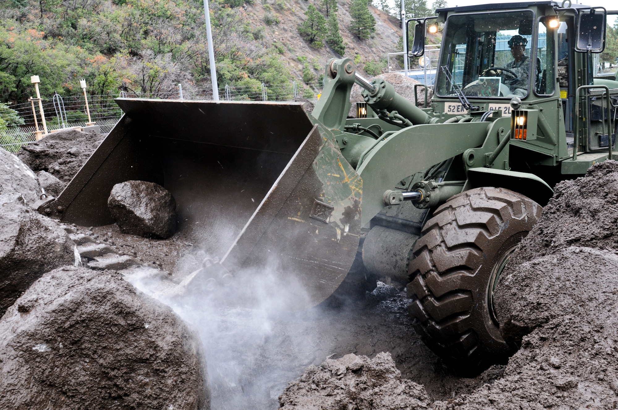 CHEYENNE MOUNTAIN AFS, Colo. -- Spc. Donald Townsend, heavy equipment operator, 615th Engineer Company, 52nd Engineer Battalion, uses his bulldozer to move large amounts of debris at the Cheyenne Mountain Air Force Station, Sept. 13, 2013. The 615th Eng. is part of the severe weather reaction team and responded to a catastrophic mudslide on the AFS. (U.S. Army photo by Sgt. William Smith, 4th Inf. Div. PAO)
