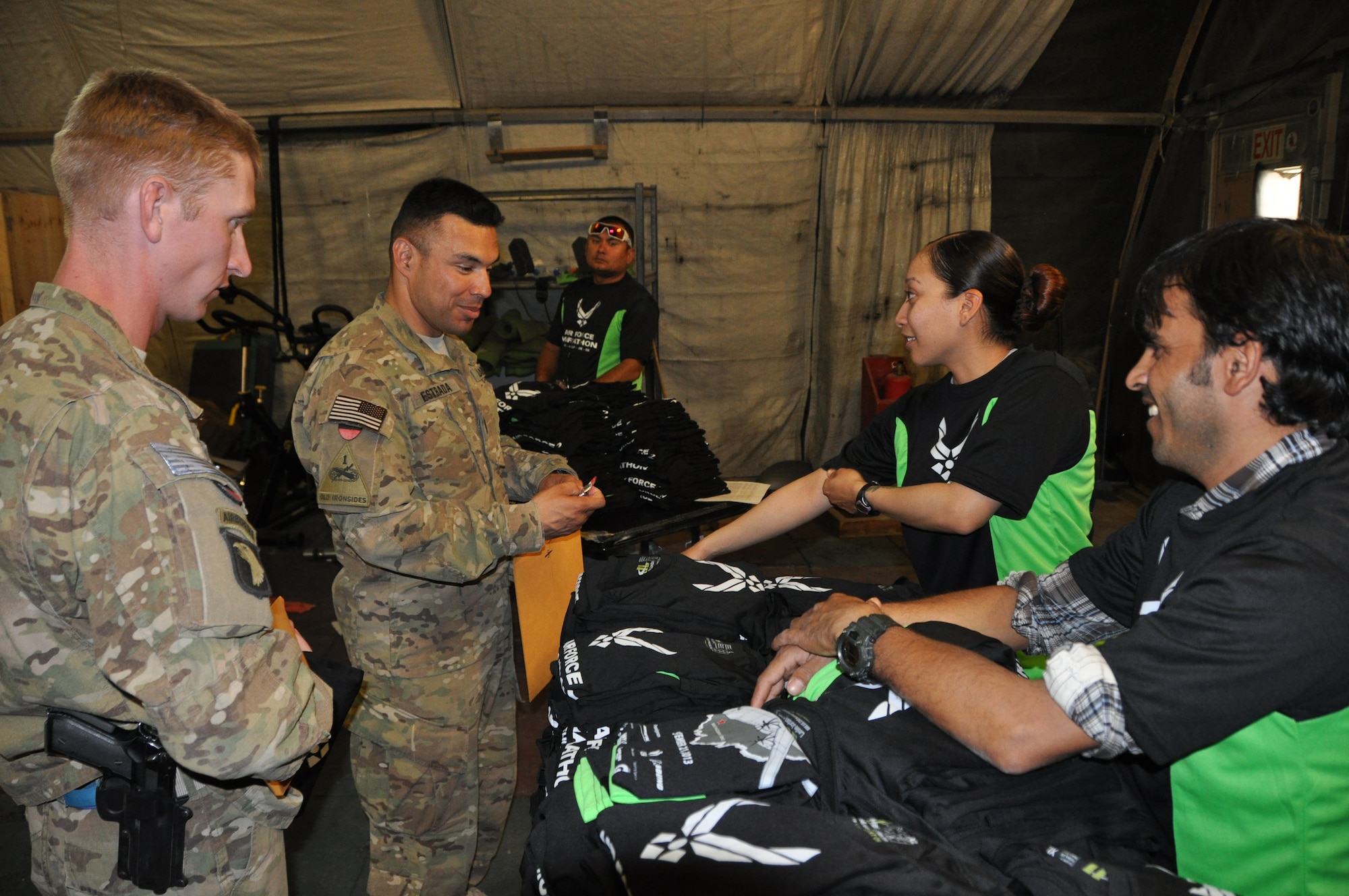 Participants pick up their race packets and t-shirts during a block party at Bagram Airfield, Afghanistan. More than 700 people participated in the 3rd annual Bagram Marathon events held here Sept. 15, 2013. The Bagram Marathon is an extension of the Air force Marathon held at Wright Patterson Air Force Base, in Dayton, Ohio, Sept. 21. Bagram is one of seven deployed locations throughout the area of responsibility that participated in the extension races. (U.S. Air Force photo/Tech. Sgt. Rob Hazelett)
