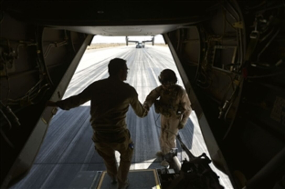 U.S Deputy Defense Secretary Ash Carter shakes the hand and presents a coin to a crew member of a V-22 Osprey after a flight to visit the U.S. Consulate in Herat, Afghanistan, Sept. 14, 2013.  A day earlier, the consulate was attacked by the Taliban.