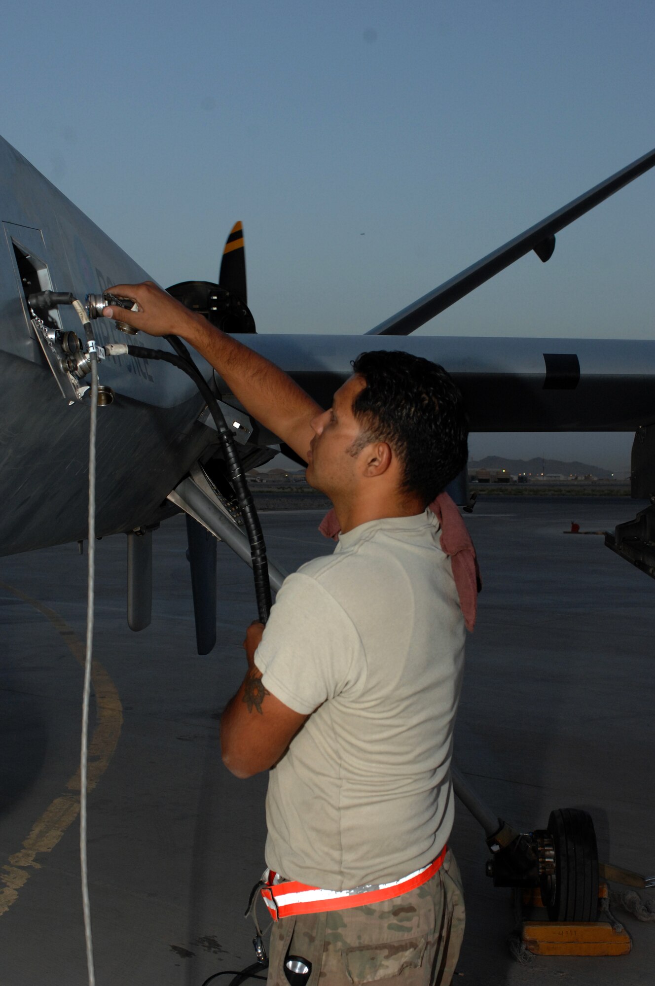 Staff Sgt. Miguel Munguia-Tovar, 451st Expeditionary Aircraft Maintenance Squadron dedicated crew chief, connects a remote terminal for the MQ-9 Reaper to test equipment before a launch Aug. 27, 2013, at Kandahar Airfield, Afghanistan. Total Force Airmen with the 451st EAMXS working on the MQ-1 and MQ-9 airframes include active duty and National Guard Airmen, and contractors. (U.S. Air Force photo/Senior Airman Jack Sanders)