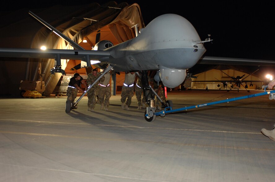 Airmen from the 451st Expeditionary Aircraft Maintenance Squadron move an MQ-9 Reaper in preparation for a mission Aug. 27, 2013, at Kandahar Airfield, Afghanistan. Members of the 451st EAMXS are building the institutional knowledge base for Reaper maintenance as they enable continuous intelligence, surveillance and reconnaissance coverage in support of Operation Enduring Freedom. 