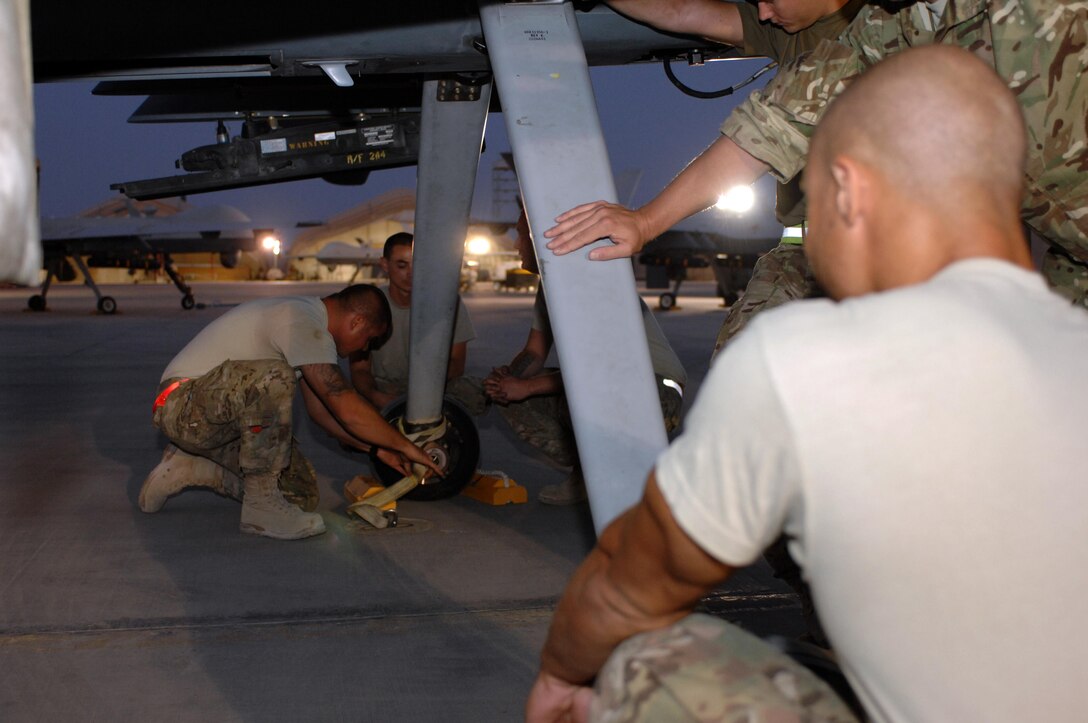 Airmen from the 451st Expeditionary Aircraft Maintenance Squadron secure an MQ-9 Reaper in preparation for a mission Aug. 27, 2013 at Kandahar Airfield, Afghanistan. Members of the 451st EAMXS are responsible for maintenance, launch and recovery for MQ-1 and MQ-9 aircraft. 