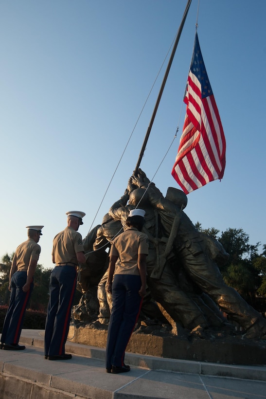 Parris Island Marines raise a flag during a ceremony in which new Marines of Delta Company, 1st Recruit Training Battalion, and Papa Company, 4th Recruit Training Battalion, received their Eagle, Globe and Anchor emblems Sept. 7, 2013, at the Iwo Jima flag raising statue on Parris Island, S.C. This ceremony has been a tradition since the first Crucible in 1996. Delta Company is scheduled to graduate Sept. 13, 2013. Parris Island has been the site of Marine Corps recruit training since Nov. 1, 1915. Today, approximately 20,000 recruits come to Parris Island annually for the chance to become United States Marines by enduring 13 weeks of rigorous, transformative training. Parris Island is home to entry-level enlisted training for 50 percent of males and 100 percent for females in the Marine Corps. (Photo by Lance Cpl. MaryAnn Hill)
