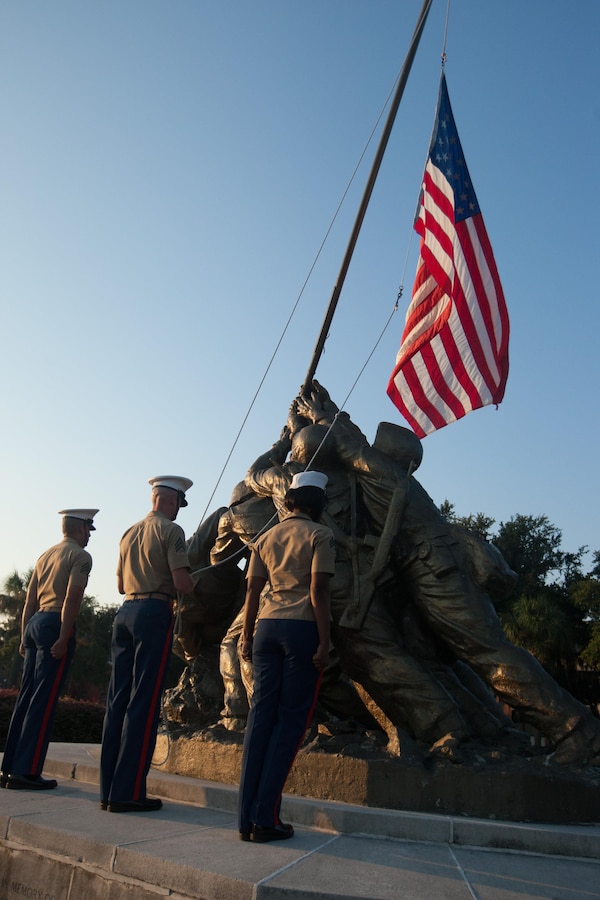 Parris Island Marines raise a flag during a ceremony in which new Marines of Delta Company, 1st Recruit Training Battalion, and Papa Company, 4th Recruit Training Battalion, received their Eagle, Globe and Anchor emblems Sept. 7, 2013, at the Iwo Jima flag raising statue on Parris Island, S.C. This ceremony has been a tradition since the first Crucible in 1996. Delta Company is scheduled to graduate Sept. 13, 2013. Parris Island has been the site of Marine Corps recruit training since Nov. 1, 1915. Today, approximately 20,000 recruits come to Parris Island annually for the chance to become United States Marines by enduring 13 weeks of rigorous, transformative training. Parris Island is home to entry-level enlisted training for 50 percent of males and 100 percent for females in the Marine Corps. (Photo by Lance Cpl. MaryAnn Hill)