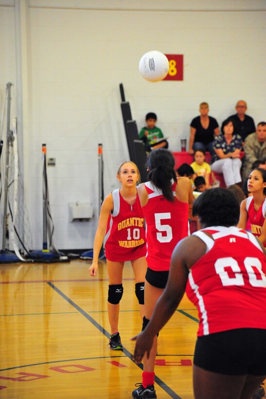 Members of the Quantico Middle/High School varsity volleyball team work together to return a ball to their opponent, Emmanuel Christian School during a game at the Quantico Middle/High School gym on Sept. 9, 2013. The Lady Warriors beat their opponent maintaining their undefeated 2013 season.