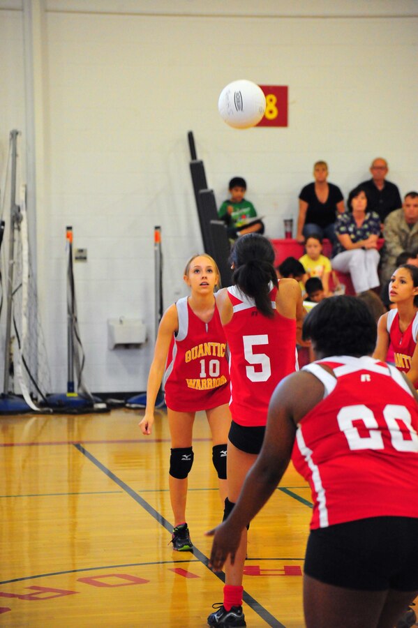 Members of the Quantico Middle/High School varsity volleyball team work together to return a ball to their opponent, Emmanuel Christian School during a game at the Quantico Middle/High School gym on Sept. 9, 2013. The Lady Warriors beat their opponent maintaining their undefeated 2013 season.