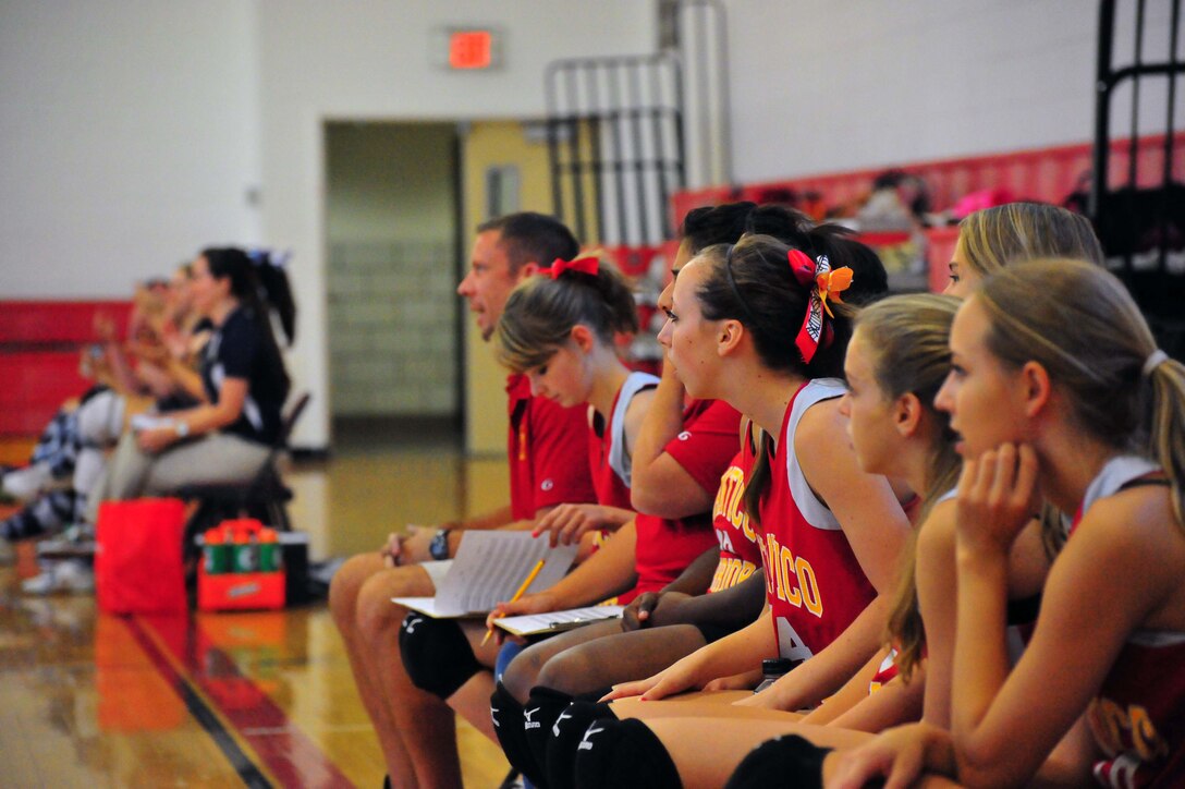 The Quantico Middle/High School varsity girl’s volleyball team and their opponent Emmanuel Christian School, from Manassas, watch their teammates play at Quantico Middle/High School on Sept. 9, 2013. The Lady Warriors beat their opponent maintaining their undefeated 2013 record.