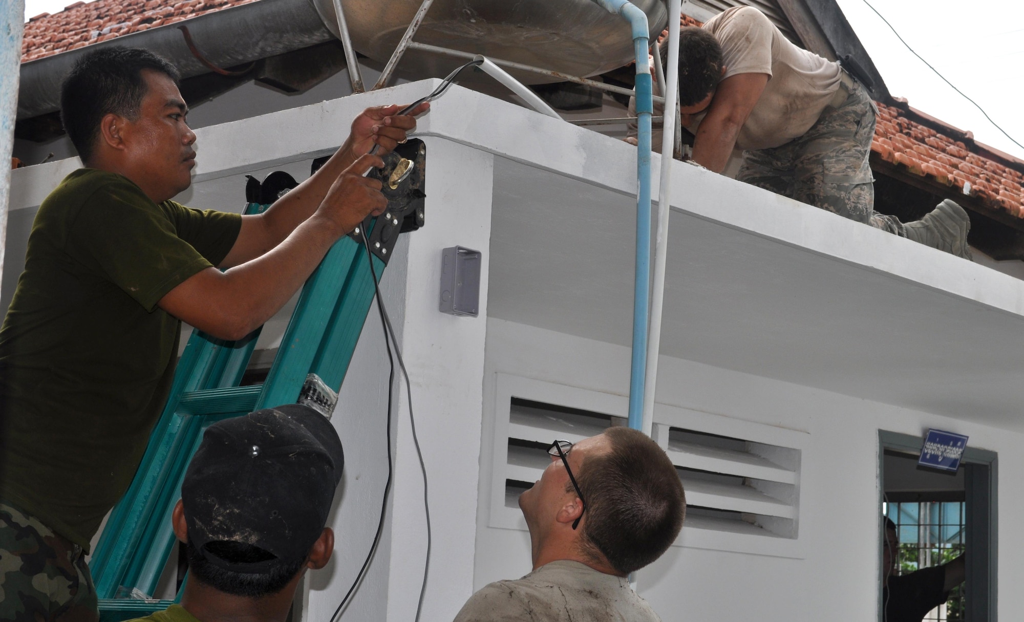 An electrician from Royal Cambodian Armed Forces assists with wiring at Tram Kok Health Canter Sept. 12 during Operation Pacific Angel 13-5 Cambodia. Work is almost complete at the site. Tram Kok and two other health centers are being renovated. The operation is scheduled to end in two days. Thirty-six U.S. forces and RCAF are working together on the health centers during engineering civil action 