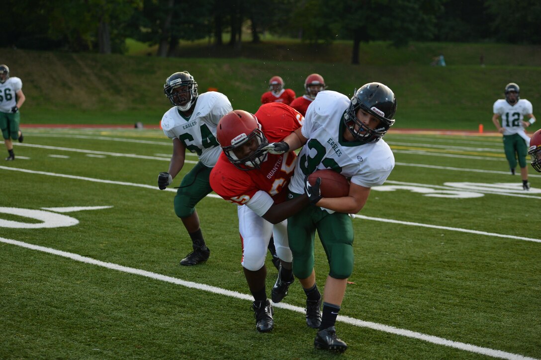 Victor, guard/tackle, Quantico Middle/High School Warriors Varsity Football Team, makes sure that a running back for the Fredericksburg Christian School Eagles does not slip through his grasp during a game at Butler Stadium aboard Marine Corps Base Quantico on Sept. 5, 2013. The Warriors kept the Eagles from scoring in the second half. 