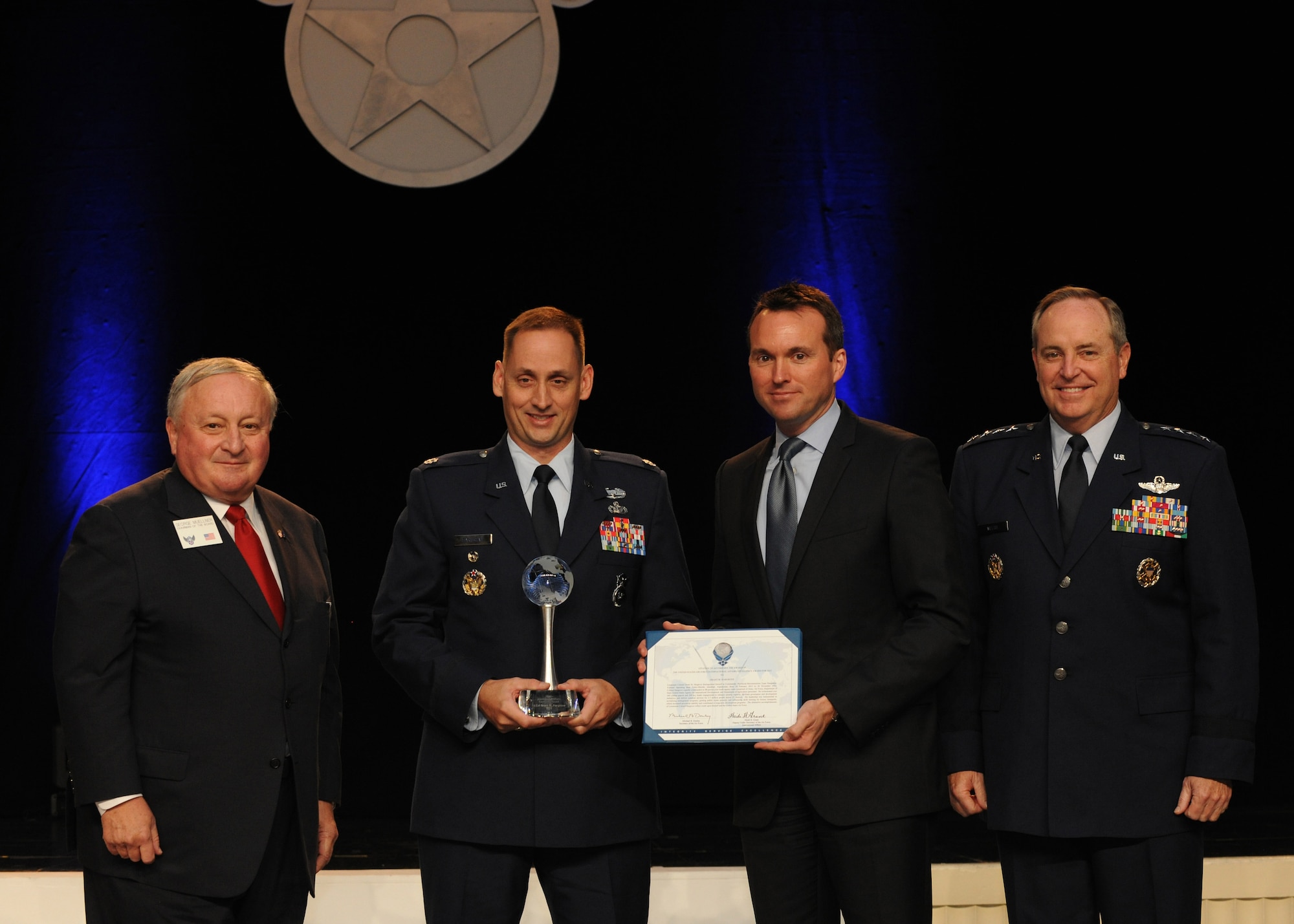 Lt Col. Grant Hargrove is presented the International Affairs Excellence Award by Acting Air Force Secretary Eric Fanning, Air Force Chief of Staff Gen. Mark A. Welsh III and George K. Muellner at the Air Force Association’s 2013 Air & Space Conference and Technology Exposition Sept. 16, 2013, in Washington, D.C. The International Affairs Excellence Award is presented annually for outstanding and innovative contributions effective in building, sustaining, expanding and guiding Air Force-to-partner relationships. Muellner is the Air Force Association chairman of the board.  (U.S. Air Force photo/Airman 1st Class Aaron Stout) 