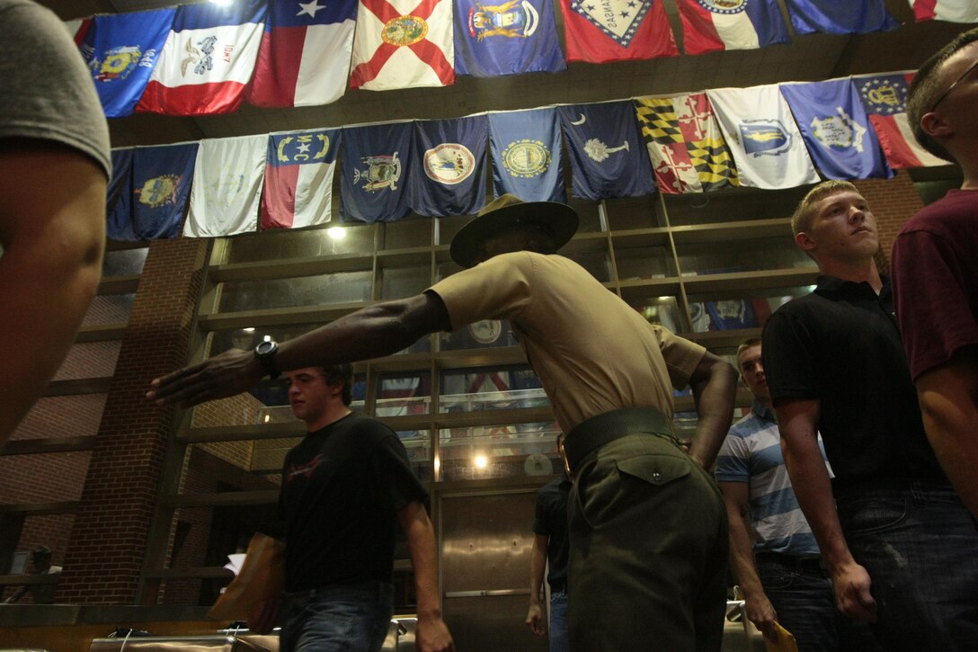 Sgt. Abraham Miller, a drill instructor, directs recruits of Kilo Company, 3rd Recruit Training Battalion, into the receiving building Aug. 26, 2013, on Parris Island, S.C. Miller, 26, from Trenton, N.J., is one of a handful of drill instructors responsible for preparing new recruits for training. Kilo Company is scheduled to graduate Nov. 22, 2013. Parris Island has been the site of Marine Corps recruit training since Nov. 1, 1915. Today, approximately 20,000 recruits come to Parris Island annually for the chance to become United States Marines by enduring 13 weeks of rigorous, transformative training. Parris Island is home to entry-level enlisted training for 50 percent of males and 100 percent of females in the Marine Corps. (Photo by Cpl. Caitlin Brink)