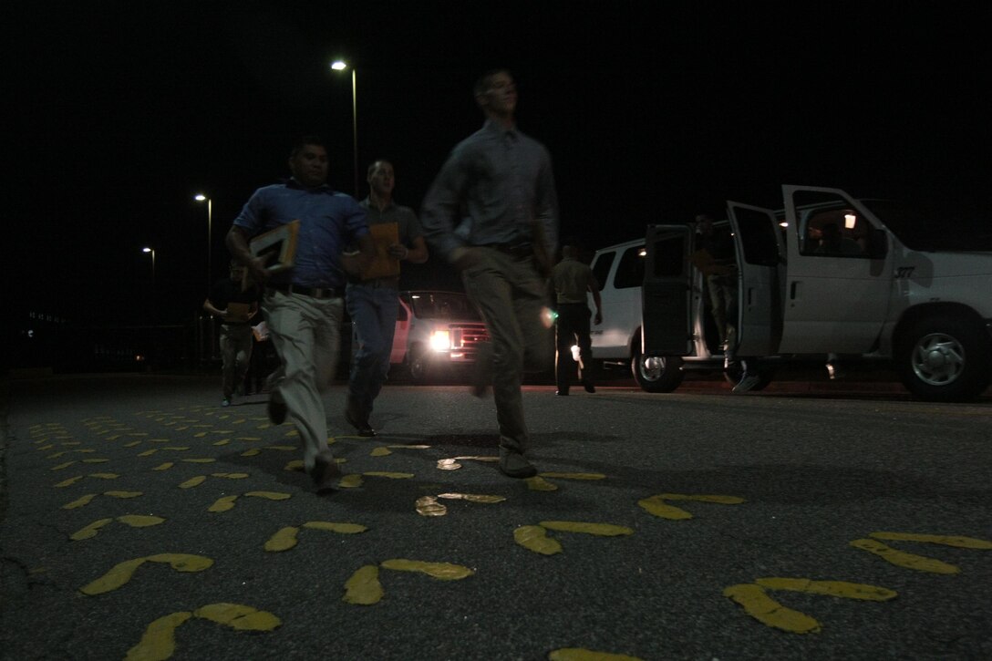Future recruits of Kilo Company, 3rd Recruit Training Battalion, sprint out of vans and onto the yellow footprints Aug. 26, 2013, on Parris Island, S.C. Vehicles loaded with soon-to-be recruits began arriving at Parris IslandâEUR(TM)s receiving building at 6 p.m., and trickled in throughout the next few days. Kilo Company is scheduled to graduate Nov. 22, 2013. Parris Island has been the site of Marine Corps recruit training since Nov. 1, 1915. Today, approximately 20,000 recruits come to Parris Island annually for the chance to become United States Marines by enduring 13 weeks of rigorous, transformative training. Parris Island is home to entry-level enlisted training for 50 percent of males and 100 percent of females in the Marine Corps. (Photo by Cpl. Caitlin Brink)