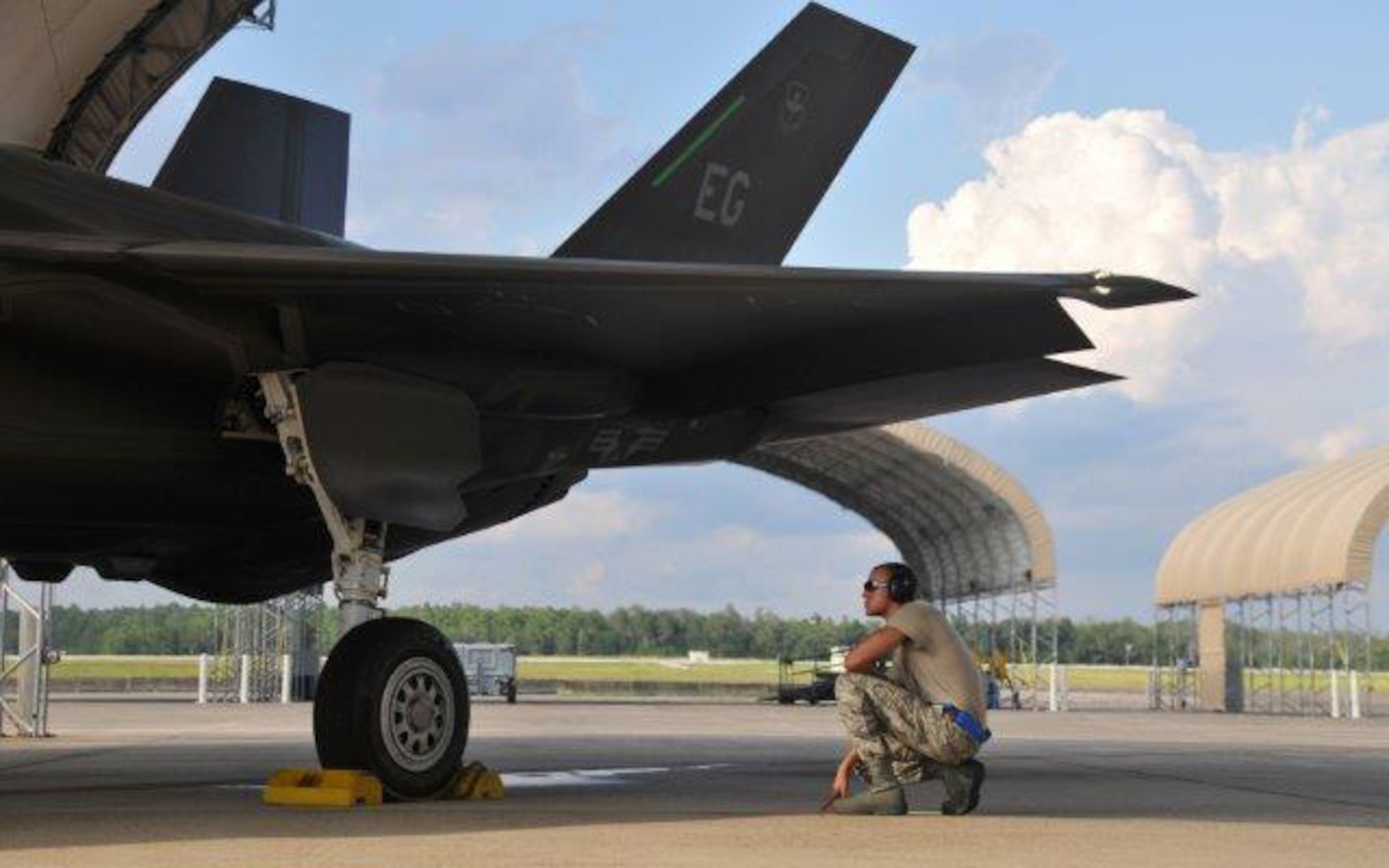 Senior Airman Jeremy McKague stands by to pull chocks after an F-35 Lightning II joint strike fighter pilot performs a preflight inspection before a training and testing mission June 20, 2013, at Eglin Air Force Base, Fla. The aircraft is still in the testing phase and will be used by the  Air Force, Navy and Marine Corps, along with international partners such as the United Kingdom. McKague is an aircraft armament systems journeyman assigned to the 33rd Maintenance Group. 