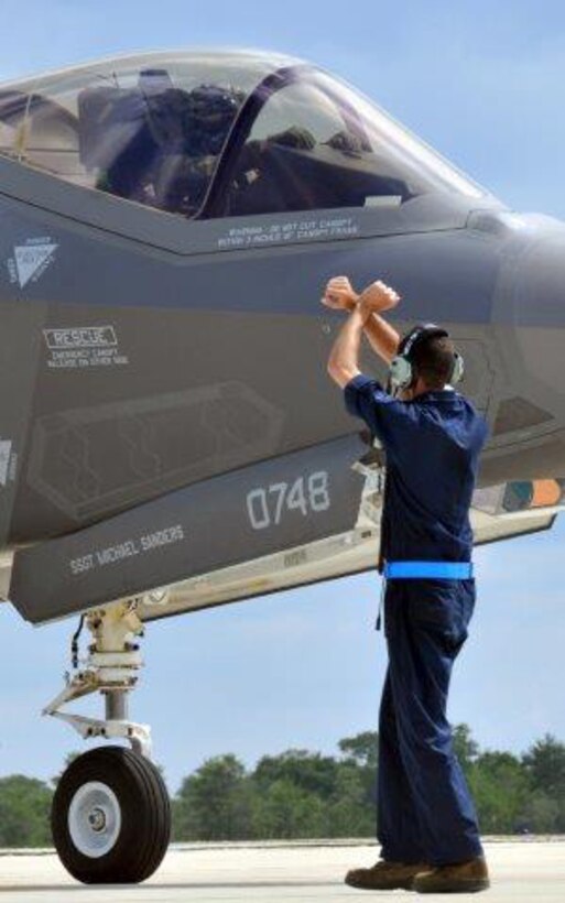 Senior Airman Jeremy Houser gives parking directions to F-35 Lightning II pilot Col. Stephen Jost, the 33rd Operations Group commander, during a quick-turn hot pit refueling mission June 20, 2013, at Eglin Air Force Base, Fla. Both Airmen are assigned to the 33rd Fighter Wing and are part of the testing program for the fifth generation fighter. Houser is an F-35 Lightning II joint strike fighter crewchief assigned to the 33rd Maintenance Group. 