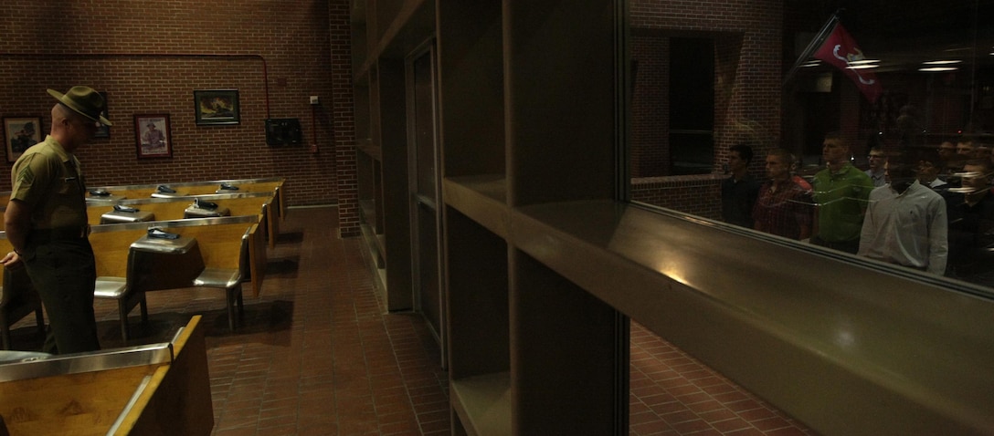 Sgt. George Caldwell, a drill instructor, waits for the new recruits of Kilo Company, 3rd Recruit Training Battalion, to step through the silver doors of the receiving building, symbolizing their transition from civilian to Marine Corps recruits Aug. 26, 2013, on Parris Island, S.C. Caldwell, 25, from Beckley, W.Va., is one of a handful of drill instructors responsible for preparing new recruits for training. Kilo Company is scheduled to graduate Nov. 22, 2013. Parris Island has been the site of Marine Corps recruit training since Nov. 1, 1915. Today, approximately 20,000 recruits come to Parris Island annually for the chance to become United States Marines by enduring 13 weeks of rigorous, transformative training. Parris Island is home to entry-level enlisted training for 50 percent of males and 100 percent of females in the Marine Corps. (Photo by Cpl. Caitlin Brink)