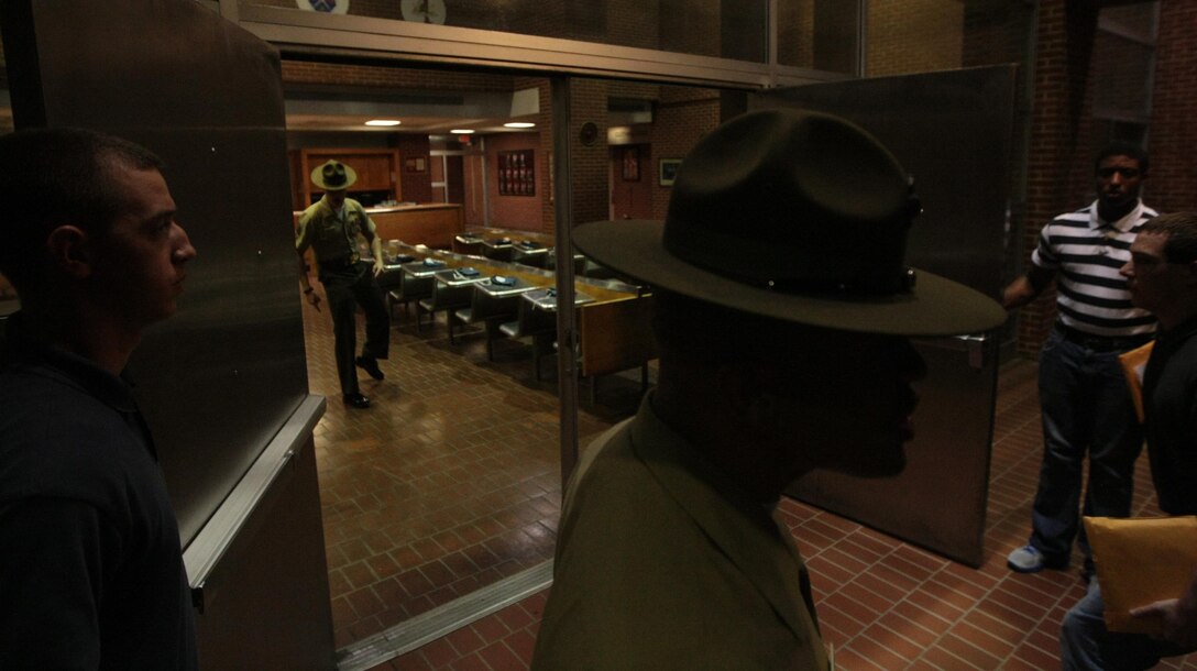 Drill instructors lead new recruits of Kilo Company, 3rd Recruit Training Battalion, through their first night of Marine Corps recruit training Aug. 26, 2013, on Parris Island, S.C. The first stressful night comes as a shock for most as they deal with sleep deprivation, new rules and ferocious drill instructors. Kilo Company is scheduled to graduate Nov. 22, 2013. Parris Island has been the site of Marine Corps recruit training since Nov. 1, 1915. Today, approximately 20,000 recruits come to Parris Island annually for the chance to become United States Marines by enduring 13 weeks of rigorous, transformative training. Parris Island is home to entry-level enlisted training for 50 percent of males and 100 percent of females in the Marine Corps. (Photo by Cpl. Caitlin Brink)