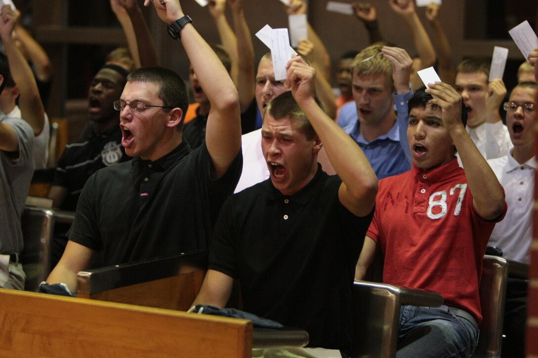 New recruits of Kilo Company, 3rd Recruit Training Battalion, hold up identification cards as they begin their in-processing shortly after arriving on Parris Island, S.C., on Aug. 26, 2013. The recruits spent the night completing paperwork and receiving haircuts and new gear in preparation for the next 13 weeks. Kilo Company is scheduled to graduate Nov. 22, 2013. Parris Island has been the site of Marine Corps recruit training since Nov. 1, 1915. Today, approximately 20,000 recruits come to Parris Island annually for the chance to become United States Marines by enduring 13 weeks of rigorous, transformative training. Parris Island is home to entry-level enlisted training for 50 percent of males and 100 percent of females in the Marine Corps. (Photo by Cpl. Caitlin Brink)