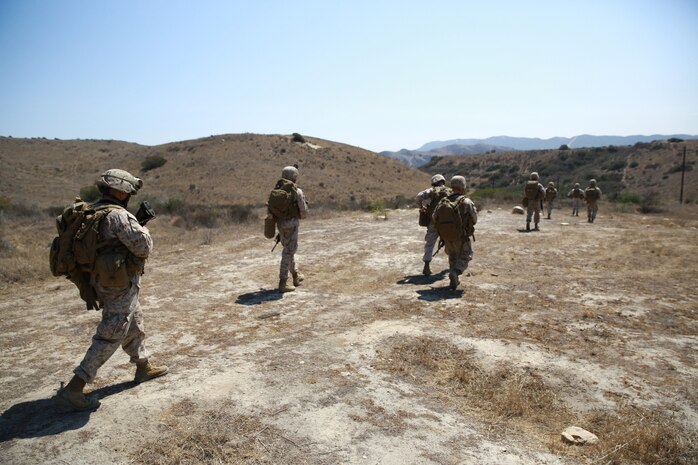 Marines serving with Headquarters Company, 3rd Battalion, 5th Marine Regiment, patrol toward their objective during tactical sight exploitation training here, Sept. 11, 2013. The Marines interacted with role-players portraying possible enemy insurgents and conducted searches for enemy weapons and intelligence. The training was designed to prepare the Marines for their upcoming deployment with the 31st Marine Expeditionary Unit.