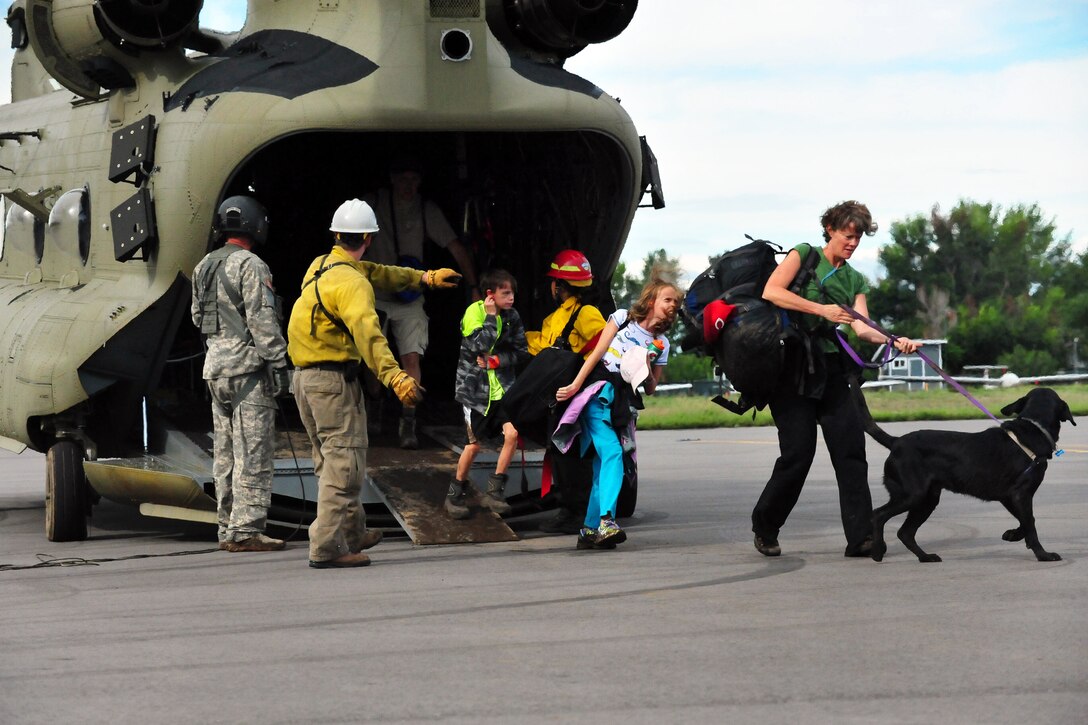 Colorado Army National Guardsmen from the 2nd Battalion 135th Aviation at Buckley Air Force Base in Aurora, Colo. and civilian rescue personnel unload evacuated residents from Colorado flood zones from a CONG CH-47 Chinook helicopter at the Boulder Municipal Airport in Boulder, Colo., Sept. 13, 2013. (Colorado National Guard photo by Sgt. Joseph K. VonNida/RELEASED)