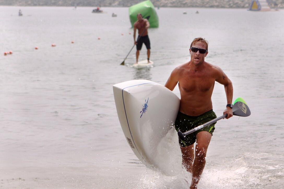 Mark Quest, 41, charges the beach as he completes one of three miles of the Age Group Amphibious Assault Stand-up Paddleboard race during the Water Warrior Beach Festival at Del Mar beach here, Sept. 14.