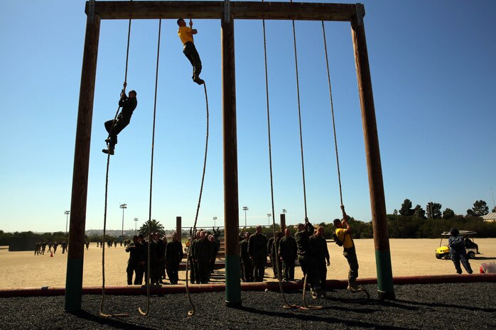 Capt. J. R. Sherwood (top center), commanding officer, Company E, 2nd Recruit Training Battalion, leads by example and shows recruits how to climb to the top of a 20 foot rope during the Obstacle Course aboard Marine Corps Recruit Depot San Diego, Sept. 5. 