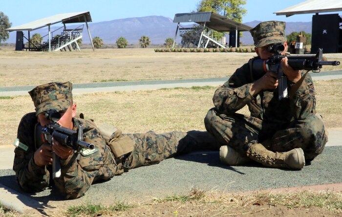 Recruits Caleb A. Allen and Tayler J. McCann of Platoon 2122, Company F, 2nd Recruit Training Battalion, practice their prone and sitting positions during Grass Week at Edson Rang aboard Marine Corps Base Camp Pendleton, Calif., Sept. 4. Recruits aim at a white barrel with targets painted on it during snap-in time. 