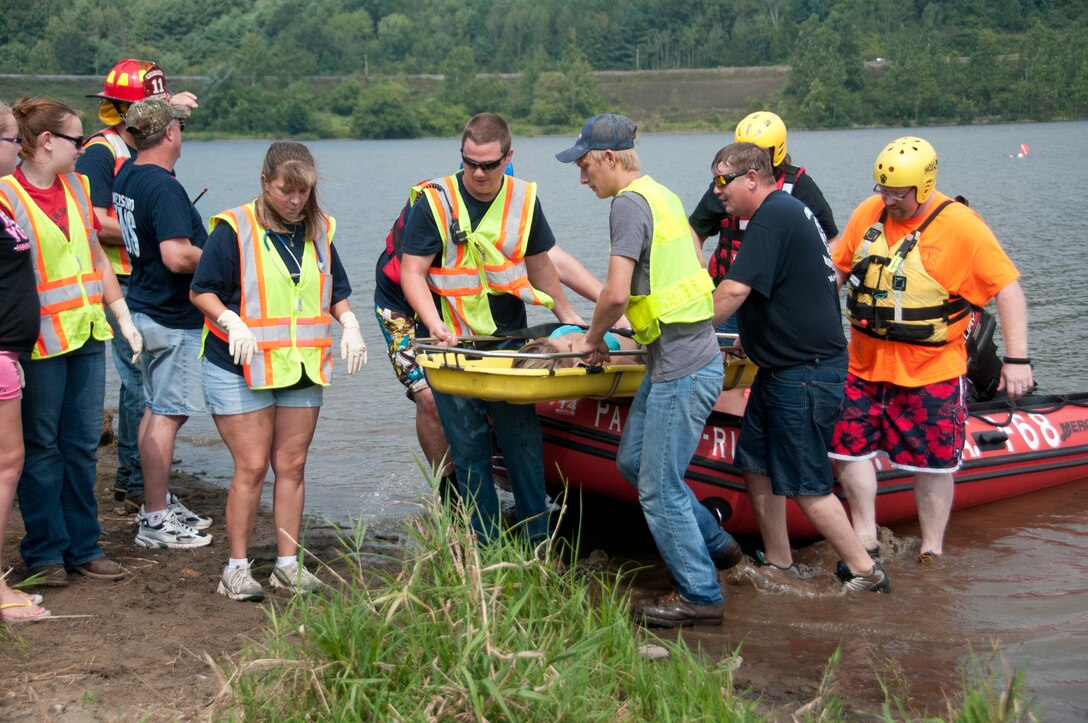 Members of the Middlebury, Tioga and Wellsboro Fire Departments work together to rescue a patient who was not wearing a life jacket when her canoe flipped over during a water rescue simulation event at Hammond Lake, Aug. 31.