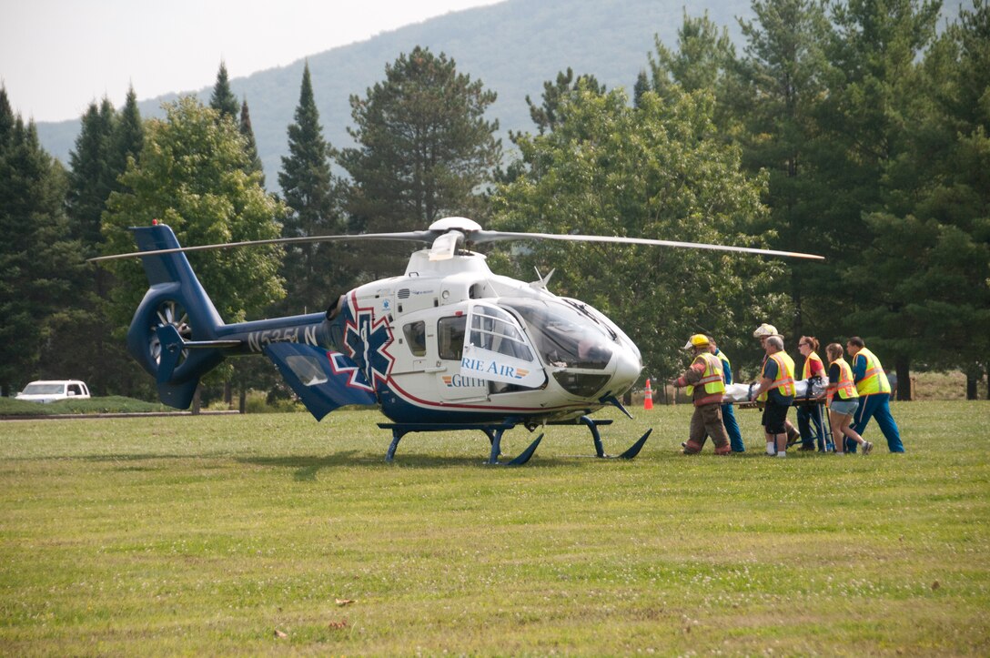 Members of the water rescue and recovery simulation team transport a patient from the ground to medical evacuation helicopter during a demonstration conducted by the Baltimore District at Tioga-Hammond and Cowanesque Lakes, Guthrie Air, Middlebury and Tioga Fire Departments and the Wellsboro Fire Department Dive Team, Aug. 31.  