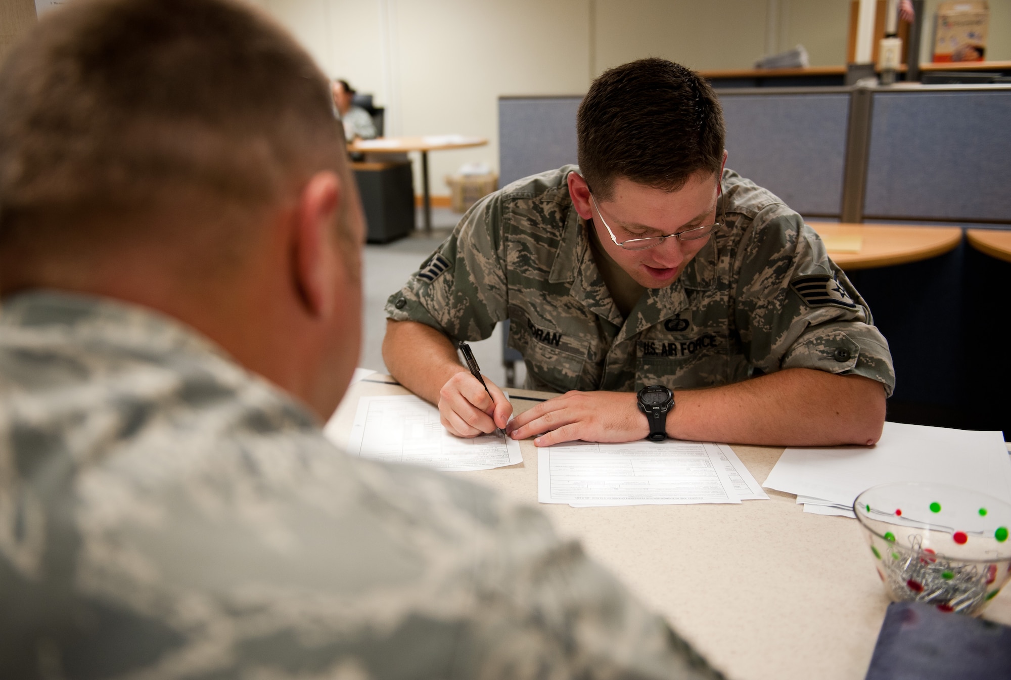 Staff Sgt. Gerard Doran, 8th Comptroller Squadron customer service NCO in-charge, assists an Airman with in-processing paperwork at Kunsan Air Base, Republic of Korea, Sept. 16, 2013. Doran and the 8th CPTS are some of the first people at the Wolf Pack newcomers meet. (U.S. Air Force photo by Senior Airman Armando A. Schwier-Morales/ Released) 