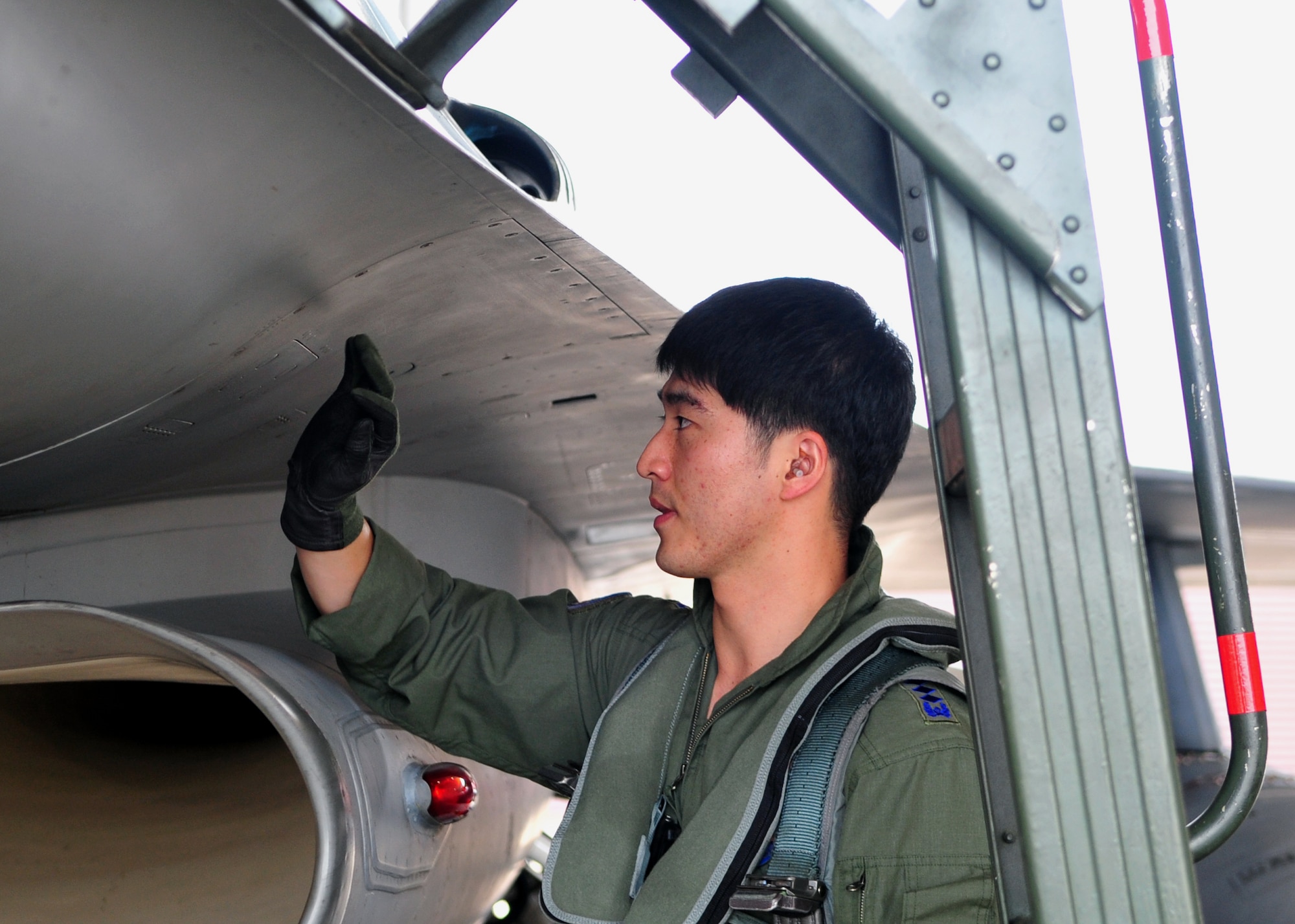 Republic of Korea air force Capt. Hyun Seung Lee, a pilot with the 161st Fighter Squadron from Jungwon Air Base, Republic of Korea, inspects a KF-16 during a Buddy Wing exchange at Osan Air Base, ROK, Sept. 12, 2013. During the exchange, Lee and another ROKAF pilot flew with pilots from the 36th Fighter Squadron. (U.S. Air Force photo/ Airman 1st Class Ashley J. Thum)