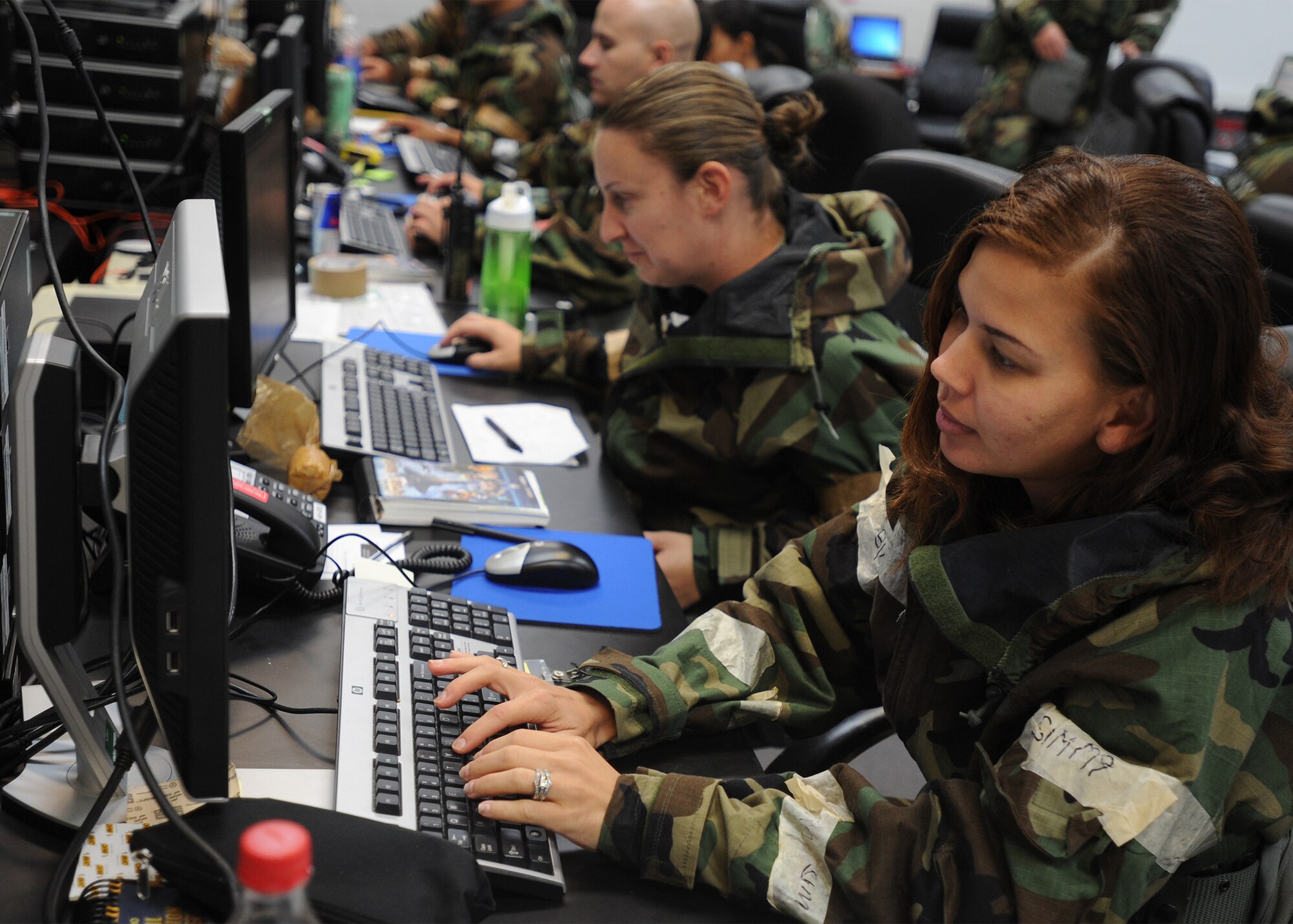 Airmen from the 15th Wing and the 154th Hawaii Air National Guard work side-by-side on exercise procedures at the Wing Operations Center, during an Operational Readiness Exercise at Joint Base Pearl Harbor Hickam, Hawaii Sept. 12, 2013. Both the 15th Wing and 154th HIANG Airmen participated in the exercise which tested war time survival skills in a Total Force Integration environment during simulated hostile situations.  (U.S. Air Force photo/Tech. Sgt. Jerome S. Tayborn)