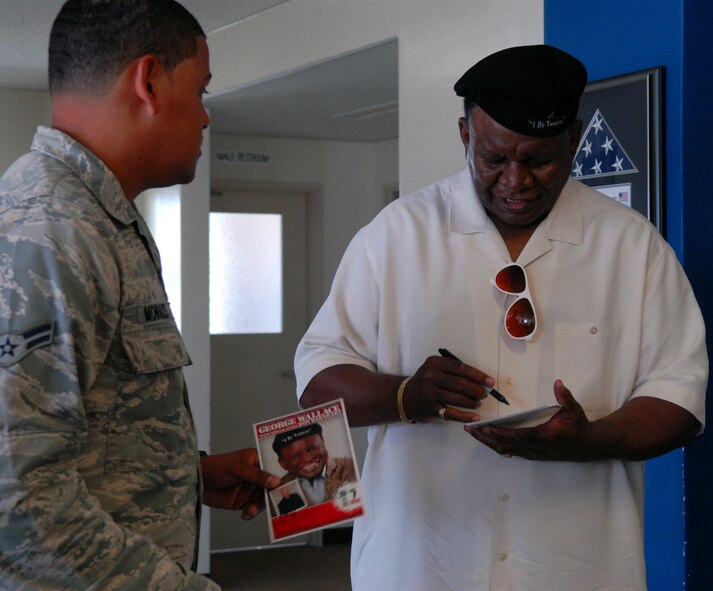 Comedian George Wallace signs an autograph for an 18th Security Forces Squadron Airman during a squadron visit on Kadena Air Base, Japan, Sept. 6, 2013. Wallace flew from Las Vegas to visit overseas troops and performed two free shows on Okinawa during USO?s Celebrity Comedy Tour.  (U.S. Air Force photo by Staff Sgt. Lauren Snyder)