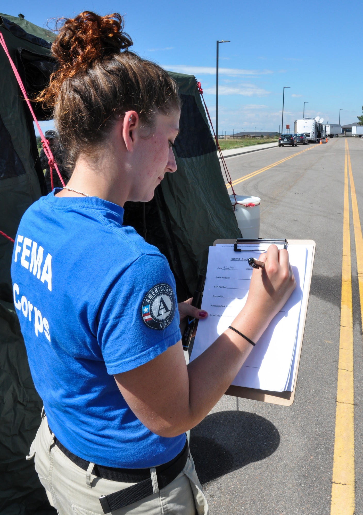Denise Corrieri, Federal Emergency Management Agency Corps logistics specialist team member, checks a staging list Sept. 16, 2013, at Buckley Air Force Base, Colo. FEMA Corps lent a hand by checking logistics and inventorying trucks in support of flood relief in Colorado. Major flood relief efforts became necessary after up to 15 inches of rain fell along the Front Range causing flash flooding, according to weather services. (U.S. Air Force photo by Staff Sgt. Nicholas Rau/Released)