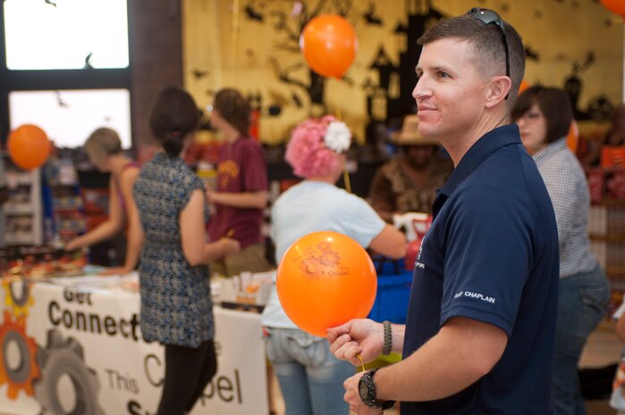 U.S. Air Force Chaplain (Capt.) Glenn Harris, 99th Air Base Wing chaplain, hands out cookies and balloons to customers at the commissary Sept. 14, 2013, at Nellis Air Force Base, Nev. The event was a part of the Get Connected kick off, offering 99th ABW Chapel members the opportunity to let Nellis AFB, Creech AFB, and Nevada Test and Training Range Airmen know how they can get involved in the chapel community and bolster their spiritual fitness. (U.S. Air Force photo by Staff Sgt. Christopher Hubenthal)