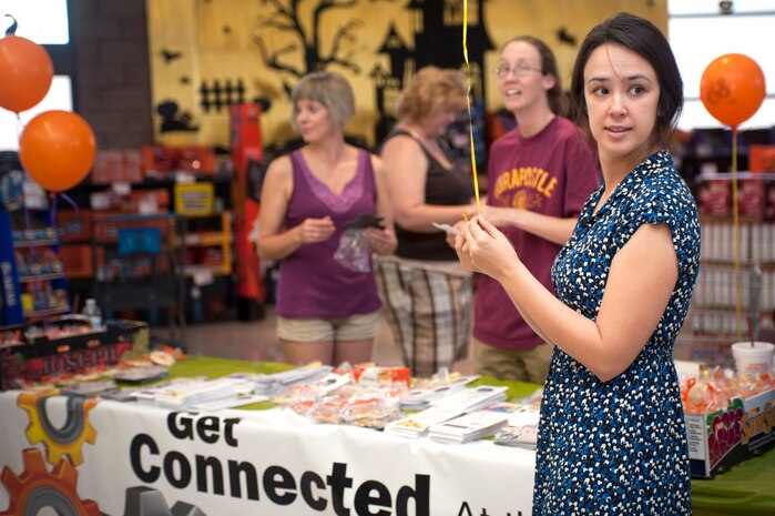 U.S. Air Force Reserve Chaplain (Capt.) Amy O'Connell, 99th Air Base Wing chaplain, hands out cookies and balloons to customers at the commissary Sept. 14, 2013, at Nellis Air Force Base, Nev. The event was a part of the Get Connected kick off, offering 99th ABW Chapel members the opportunity to let Nellis AFB, Creech AFB, and Nevada Test and Training Range Airmen know how they can get involved in the chapel community and bolster their spiritual fitness. (U.S. Air Force photo by Staff Sgt. Christopher Hubenthal)