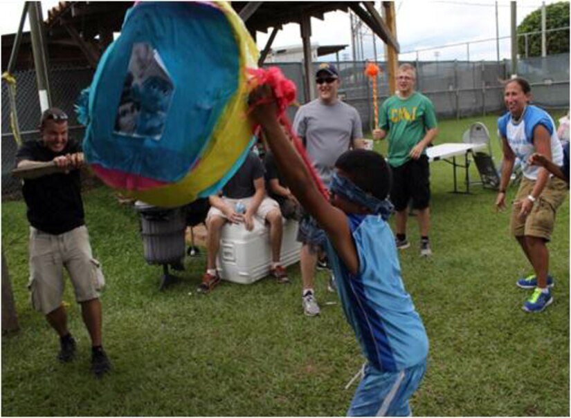 Children from the CasAyuda orphanage hit a pinata as part of a visit hosted by Joint Task Force-Bravo's Joint Security Forces, Sept. 12, 2013.  The JSF welcomed more than 30 children from the local orphanage to Soto Cano Air Base for a day of games and activities.  (Photo by U.S. Army Spc. Ryan Stufflebeem)