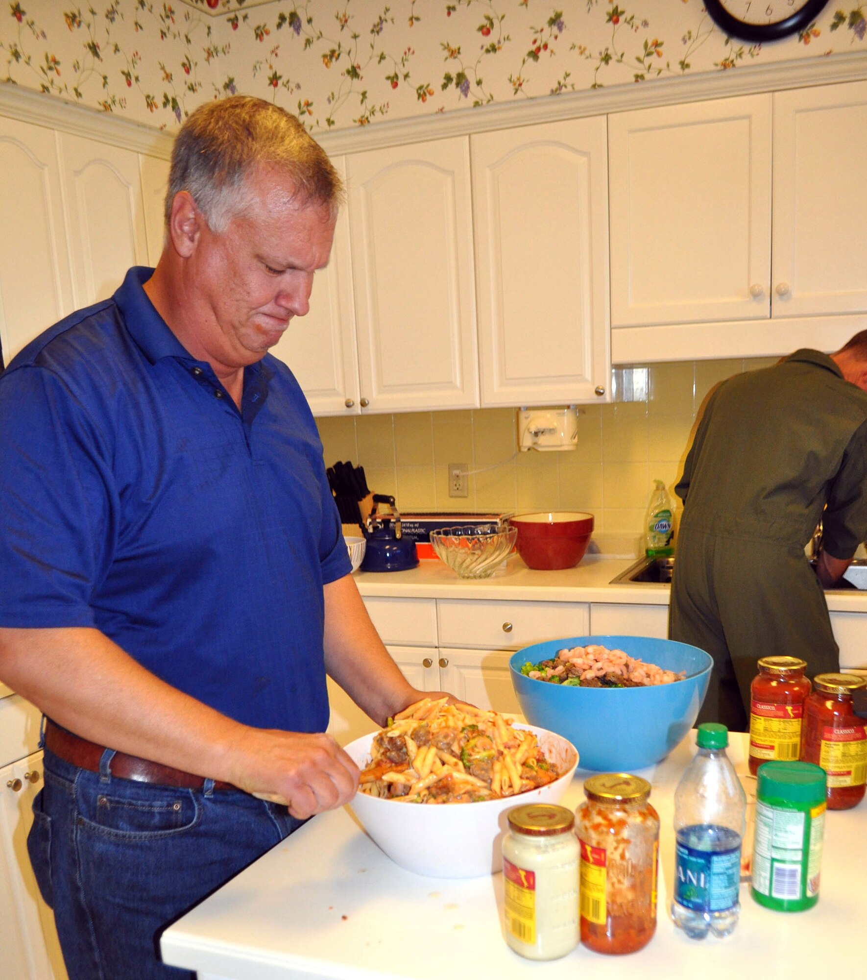 TRAVIS AIR FORCE BASE, Calif. -- Master Sgt. Stephen Burke concentrates as he creates his signature pasta recipe for families staying at the Travis Fisher House Aug. 29. Assigned to the 312th Airlift Squadron, Burke and his fellow reservists volunteered to cook dinner for families who have spent a weary day at the hospital with a suffering loved one, and are often here in their "home away from home," for weeks, even months.  (U.S. Air Force photo/Ellen Hatfield)