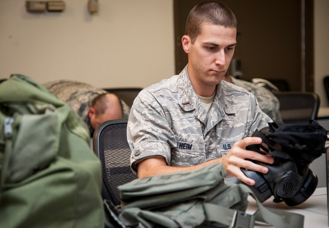 2nd Lt. Charles Heim, 47th Civil Engineer Squadron officer in charge of emergency management, inspects his gas mask prior to donning his gear at Laughlin Air Force Base, Texas, Sept. 12, 2013. Heim was part of a chemical, biological, radiological and nuclear training course here that dealt mostly with hands-on use of chemical protective equipment. (U.S. Air Force photo/Senior Airman John D. Partlow) 