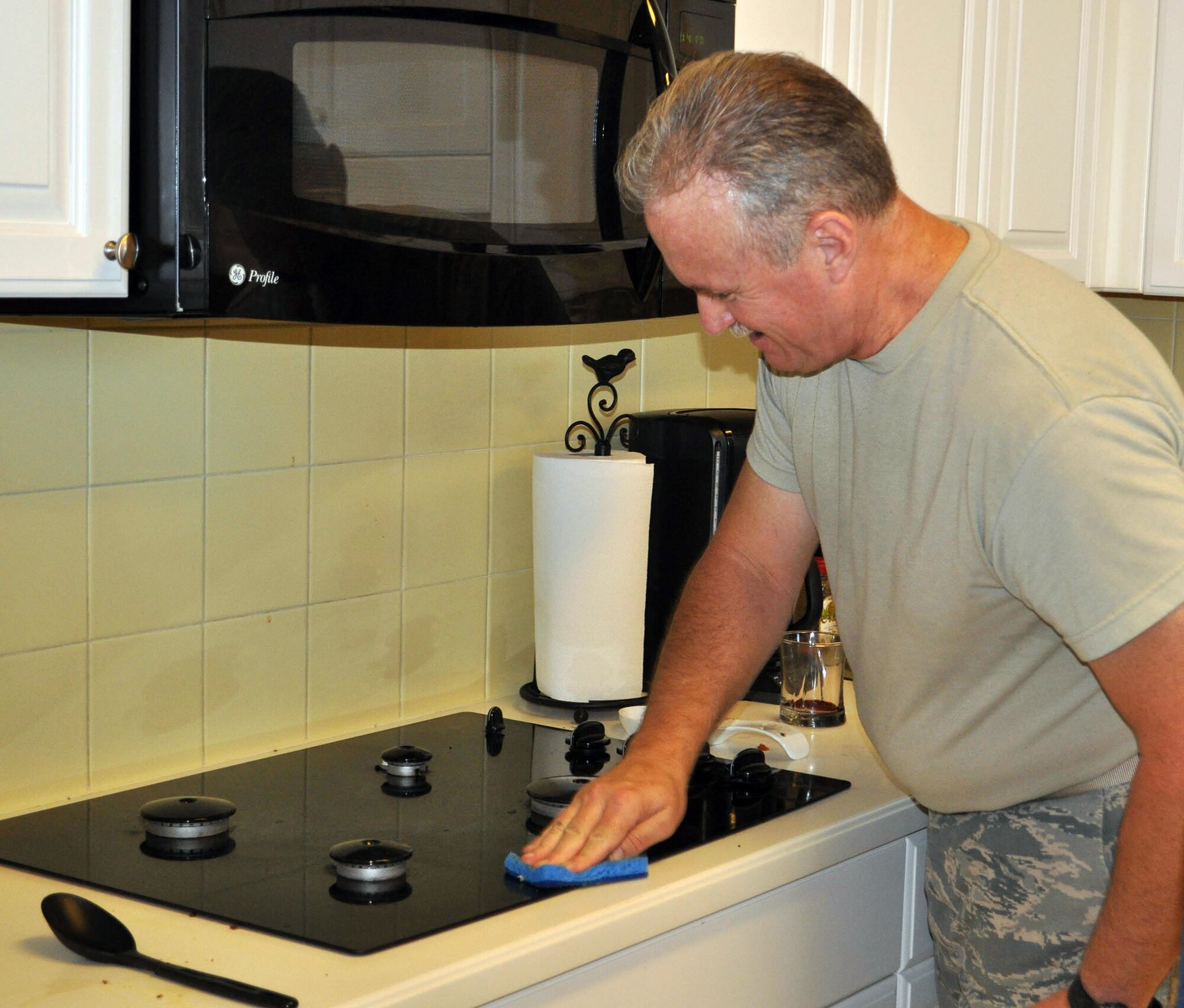 TRAVIS AIR FORCE BASE, Calif. -- Chief Master Sgt. David Lafferty applies some "elbow grease" to the stove cleanup in the kitchen of the Travis Fisher House Aug. 29. The reservists of the 312th Airlift Squadron volunteered to prepare a pasta feast for the families staying here to be close to loved ones getting medical treatment at David Grant Medical Center. "It's fun, we really enjoy doing this," said Lafferty. (U.S. Air Force photo/Ellen Hatfield)