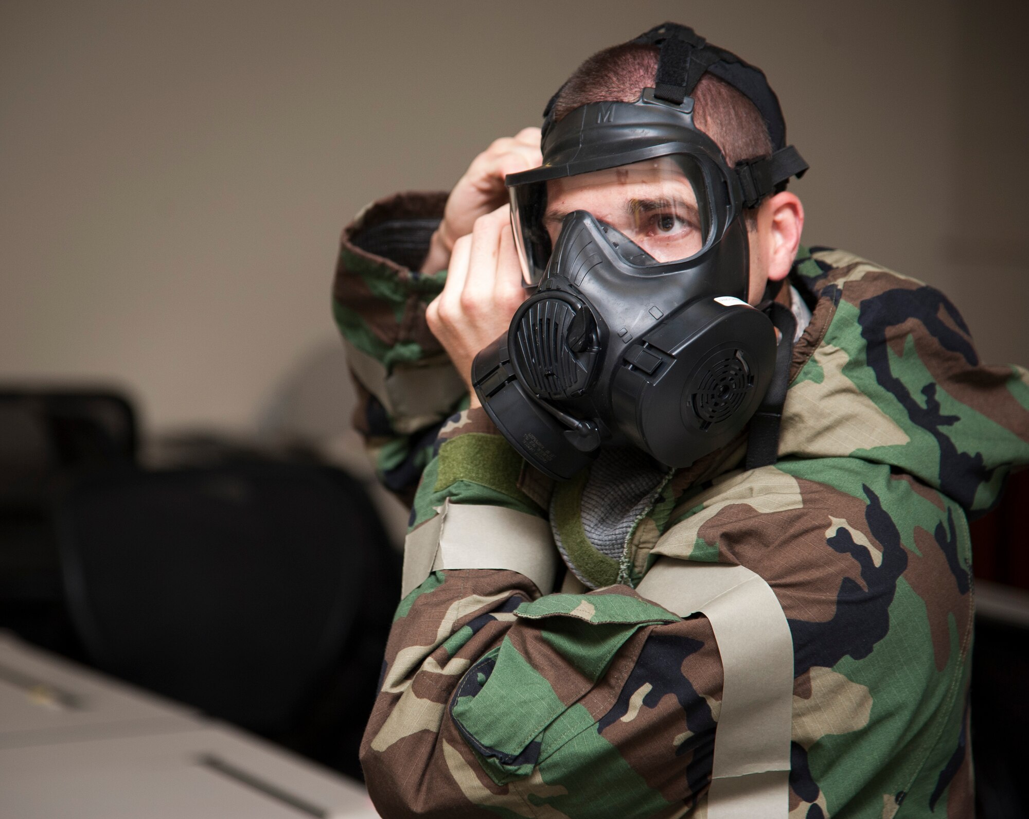 2nd Lt. Charles Heim, 47th Civil Engineer Squadron officer in charge of emergency management, secures his gas mask during a chemical, biological, radiological and nuclear training course at Laughlin Air Force Base, Texas, Sept. 12, 2013. During the course, attendees had a hands-on approach as to what may be required of them for protection during a CBRN attack. (U.S. Air Force photo/Senior Airman John D. Partlow)