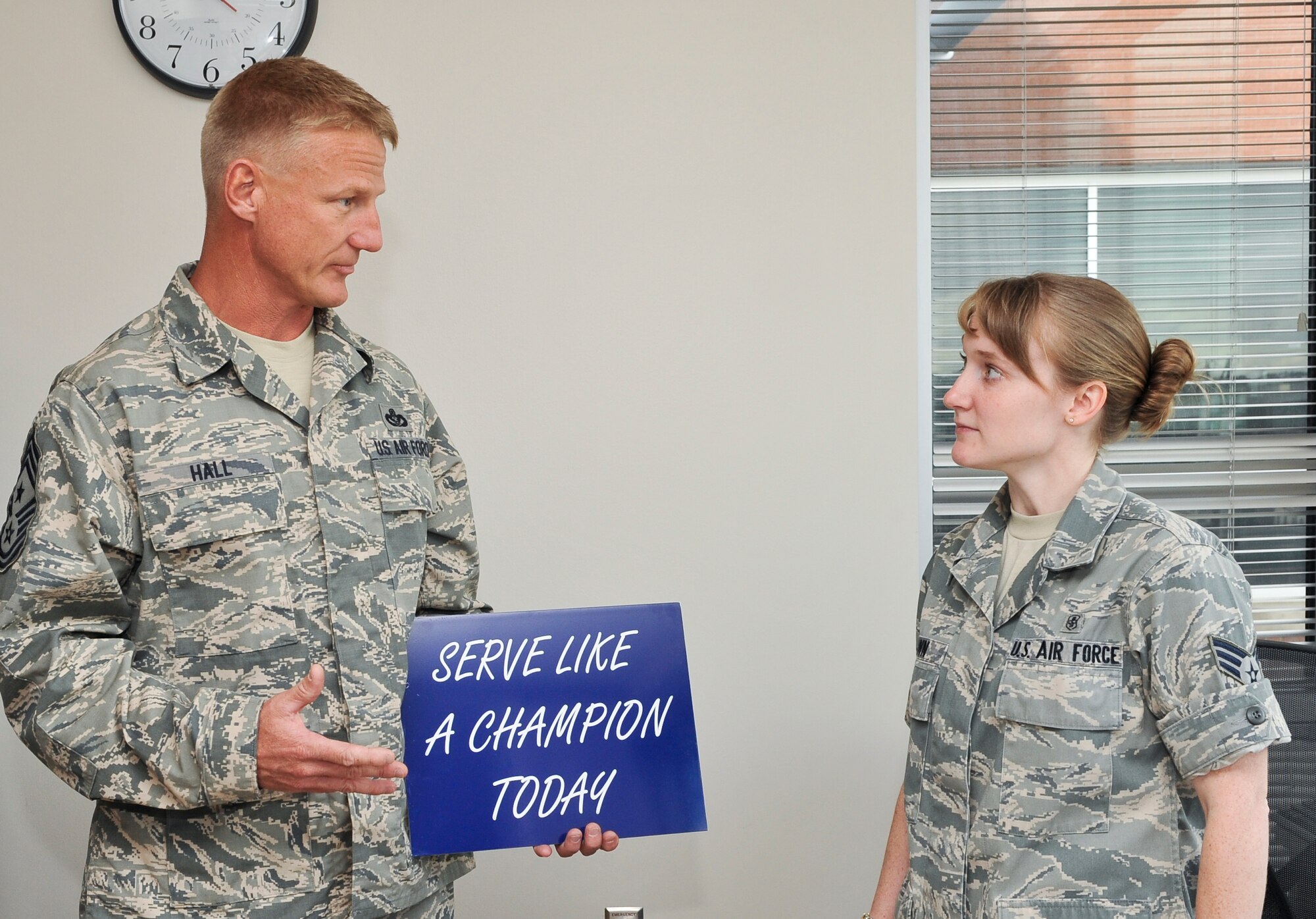 Senior Airman Regina Brown, 460th Medical Group allergy immunization technician, receives a recognition award from Chief Master Sgt. Craig S. Hall, 460th Space Wing command chief, Sept. 16, 2013, at the Veterans Affairs Joint Venture Buckley Clinic in Aurora, Colo. Brown received this award for demonstrating excellent morals and service. This is the first award Hall has given that rewards and encourages members of Team Buckley to serve like a champion. (U.S. Air Force photo by Senior Airman Phillip Houk/Released)