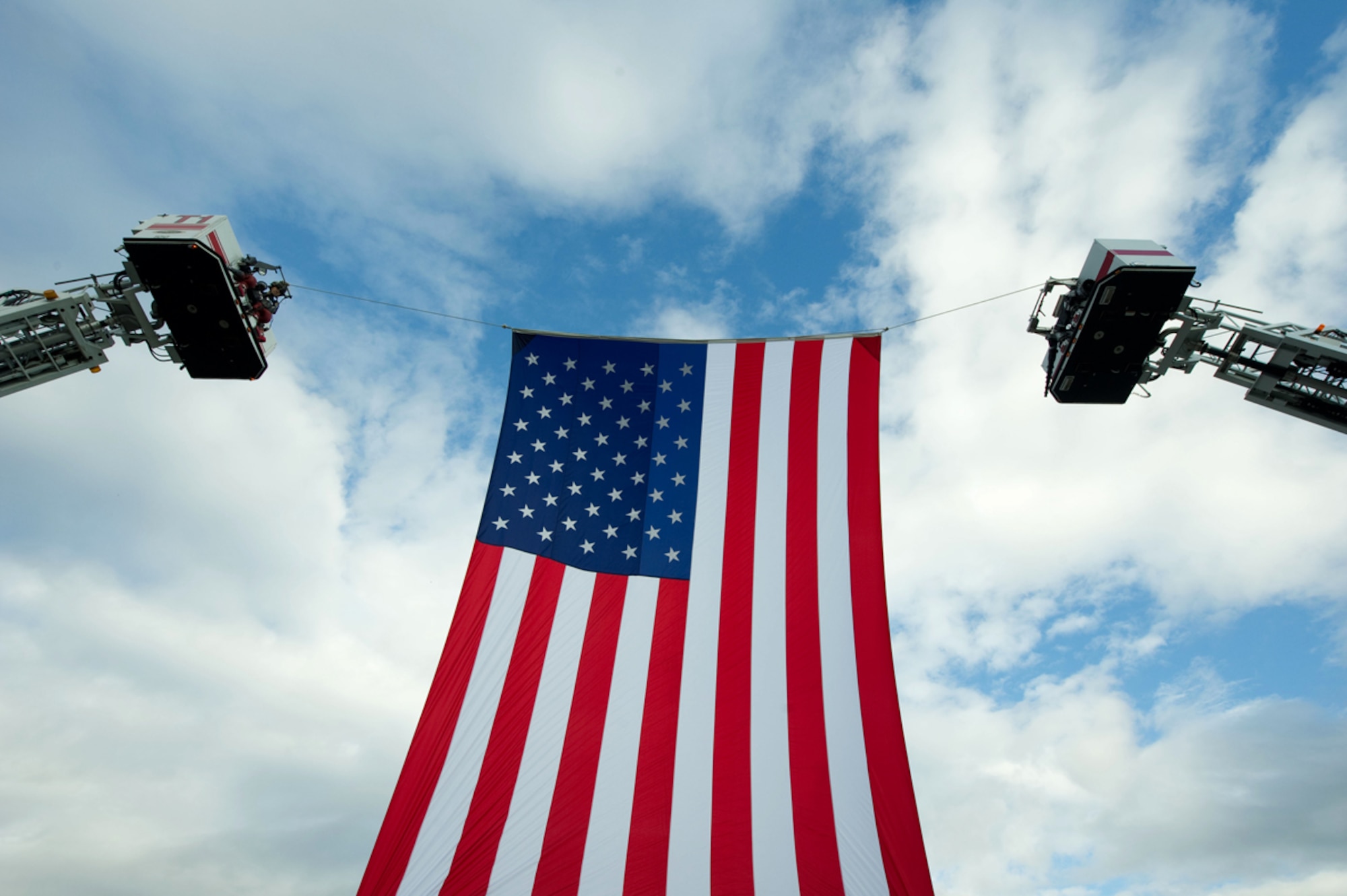 Fire Fighters from Anchorage and Central Mantanuska Valley fire departments display an American flag during the Alaska Fallen Firefighter Memorial Ceremony and 9/11 Remembrance Sept. 11, at the Alaska Fallen Firefighter Memorial. (U.S. Air Force photo/Tech. Sgt. Chris Mills) 