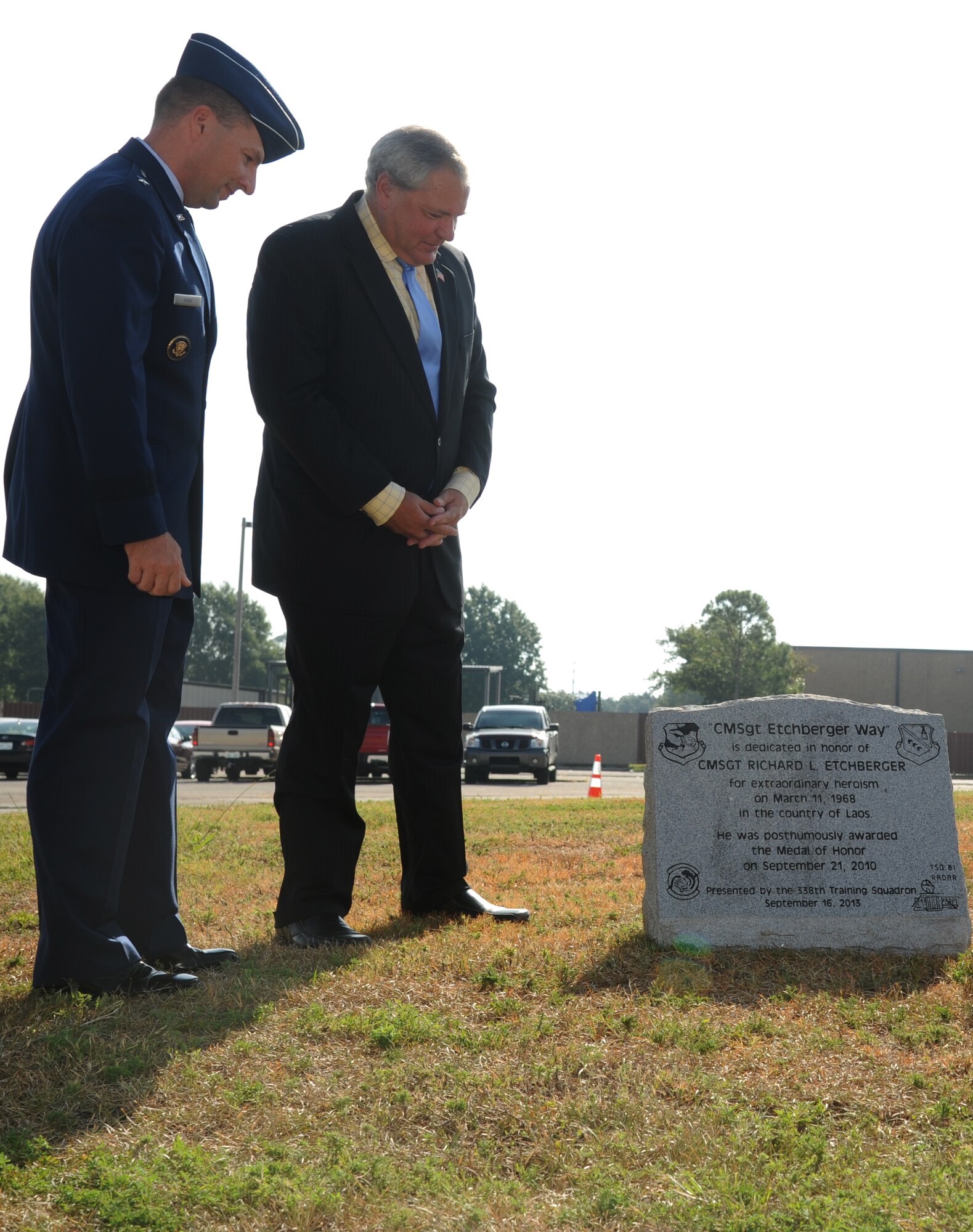 Brig. Gen. Patrick Higby, 81st Training Wing commander, and Cory Etchberger admire a memorial stone following its unveiling during a street dedication ceremony honoring Etchberger’s father and a former technical training student, Chief Master Sgt. Richard Etchberger, Sept. 16, 2013, Keesler Air Force Base, Miss. A street sign was also unveiled during the event.   (U.S. Air Force photo by Kemberly Groue)
