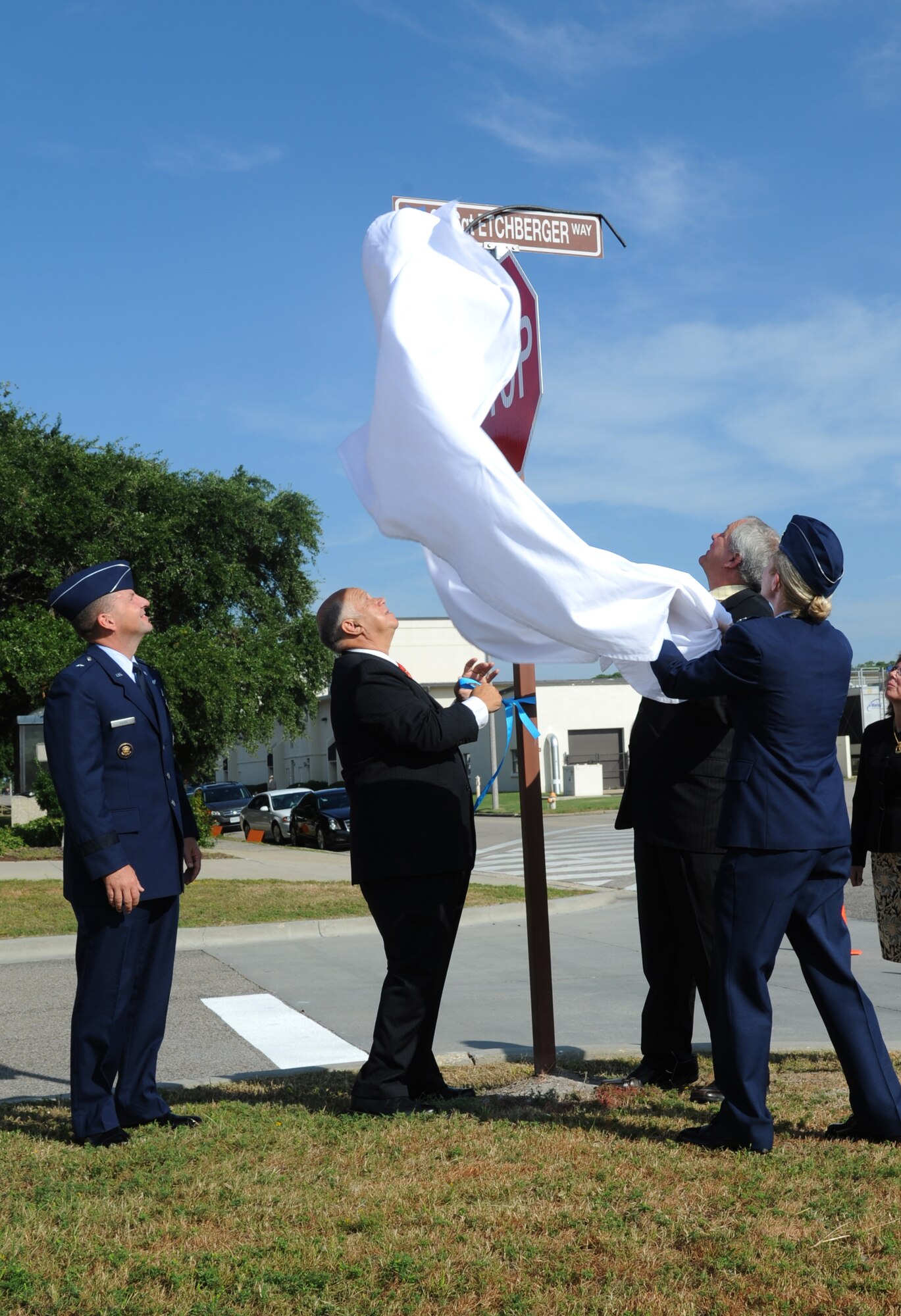 Brig. Gen. Patrick Higby, 81st Training Wing commander, watches as retired Col. Joseph Panza, Cory Etchberger and Lt. Col. Michelle Carns, 338th Training Squadron commander, unveil a street sign during the street dedication ceremony honoring a former technical training student, Chief Master Sgt. Richard Etchberger, Sept. 16, 2013, Keesler Air Force Base, Miss. Cory Etchberberger, son of Chief Etchberger, also assisted with the unveiling of a memorial stone.   (U.S. Air Force photo by Kemberly Groue)