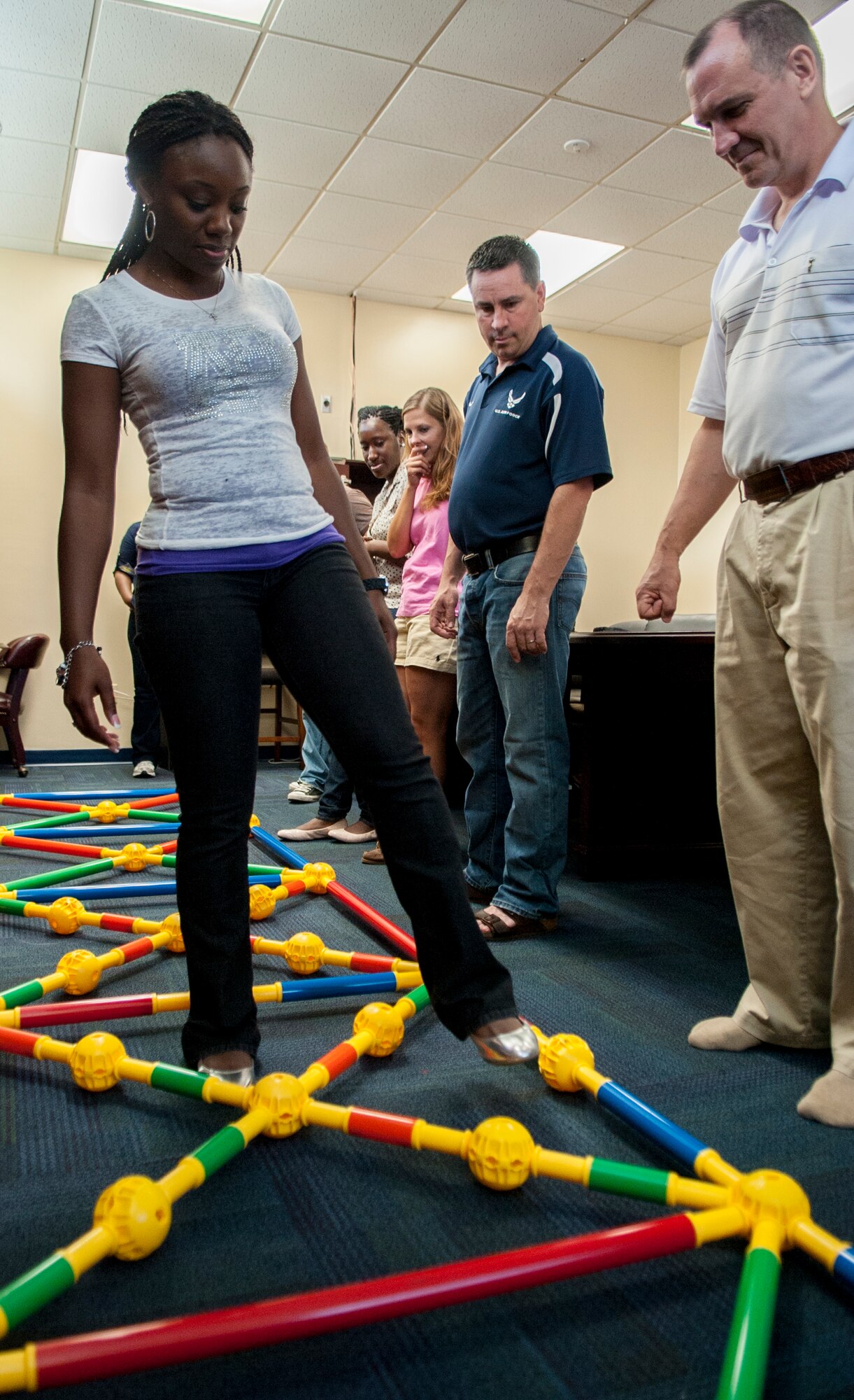 Airmen from the 23d Wing Chapel silently guide Staff Sgt. Erica Mitchell, 23d Wing Chapel chaplain assistant, through a maze during a workplace communication class at Moody Air Force Base, Ga., Sept. 9, 2013. The group had to figure out the specific series of predetermined steps to get through the maze. (U.S. Air Force photo by Airman 1st Class Sandra Marrero/Released). 
