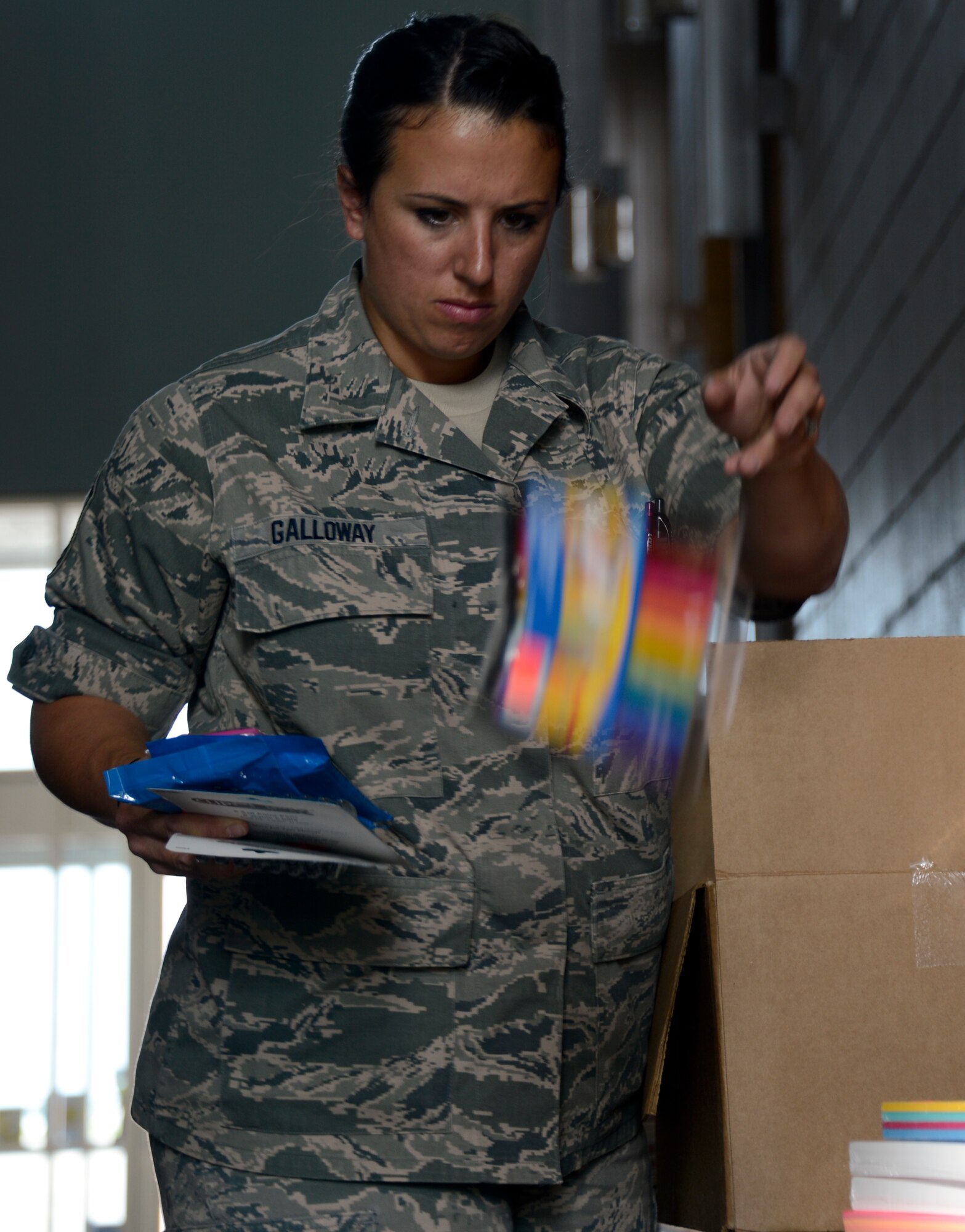 Master Sgt. Crystal Galloway, 133rd Maintenance Operations Flight, tosses makers into the pile for donation in St. Paul, Minn., Aug. 15, 2013. The school supplies were donated from customers at Dollar Trees stores throughout the Twins Cities area in support of Operation Homefront and the Back-to-School-Brigade.  

(U.S. Air National Guard photo by Tech. Sgt. Amy M. Lovgren/ Released) 

