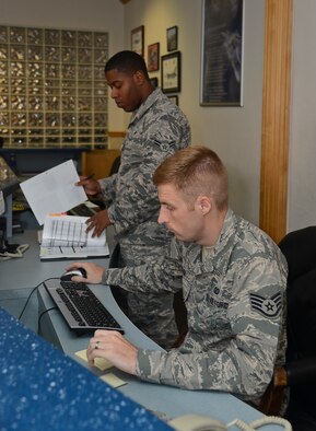 Staff Sgt. Matthew Baum, 6th Operations Squadron airfield management operations supervisor, and Airman 1st Class Issac Butler, 6 OS airfield management coordinator, prepare for the duty day at MacDill Air Force Base, Fla., Sept. 11, 2013. Airfield Management is responsible for entering flight plans for local and transit aircraft, sending notifications for in-flight and ground emergencies as well as weather notifications. (U.S. Air Force photo by Senior Airman Melanie Bulow-Kelly/Released)