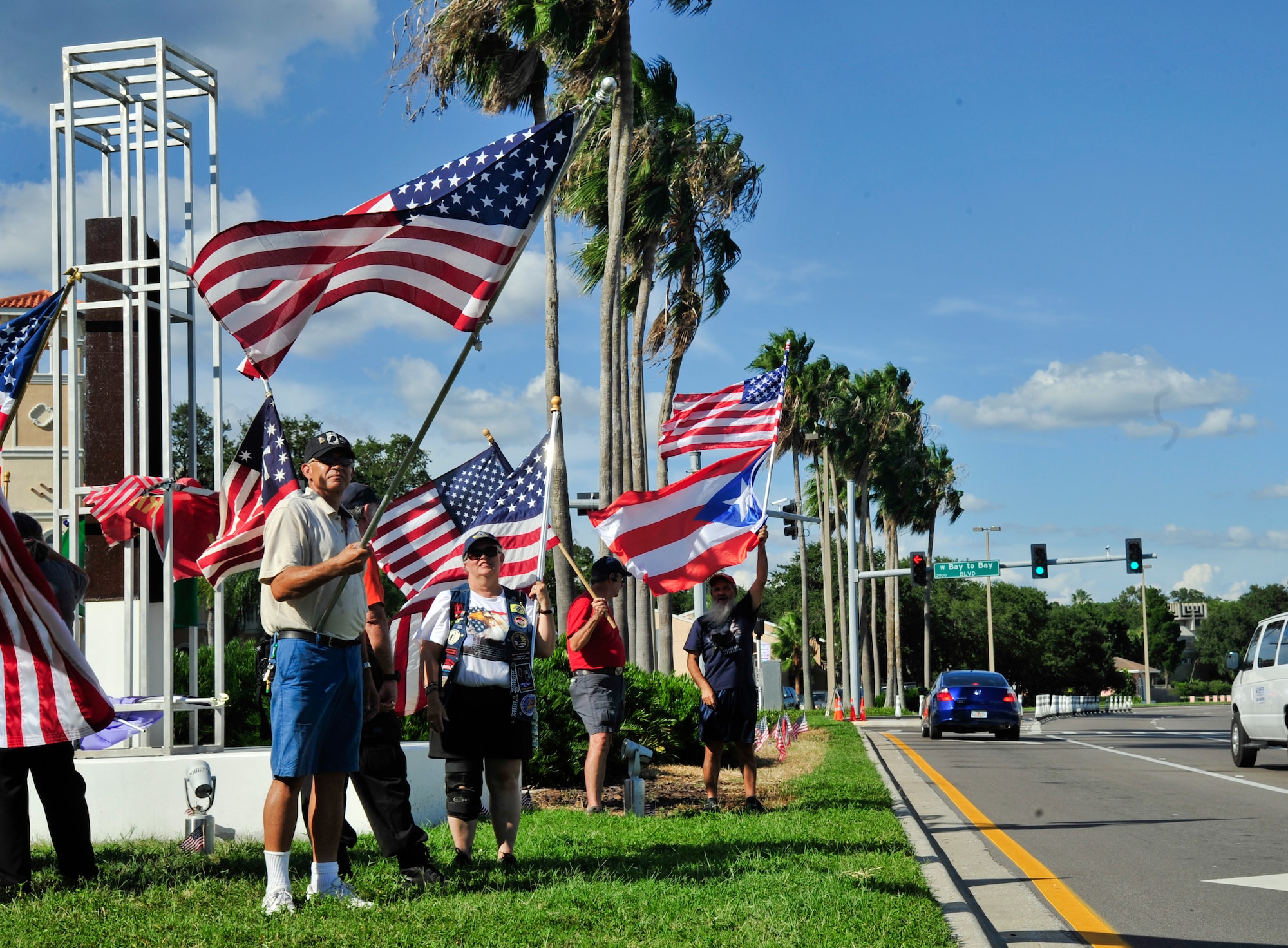 Members of the Bayshore Patriots wave American flags as vehicles drive by Sept. 11, 2013 at the 9/11 memorial on Bayshore Boulevard in Tampa, Fla. The Bayshore Patriots are present on the corner of Bay to Bay Avenue and Bayshore Boulevard every Friday, showing their support for all first responders, including military members. (U.S. Air Force photo by Airman 1st Class Sarah Hall-Kirchner/Released)